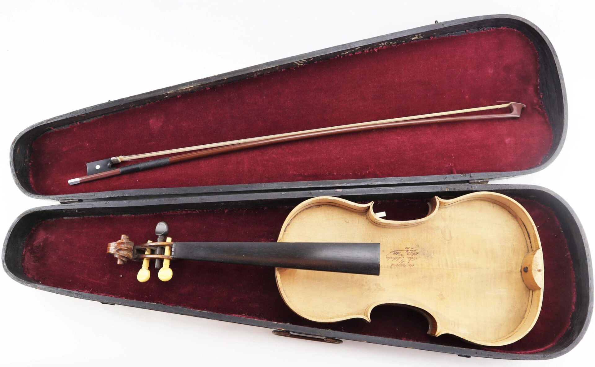 A Violin / Sold with yellow tuning pegs and its bow are displayed in an open hard case lined with red velvet.