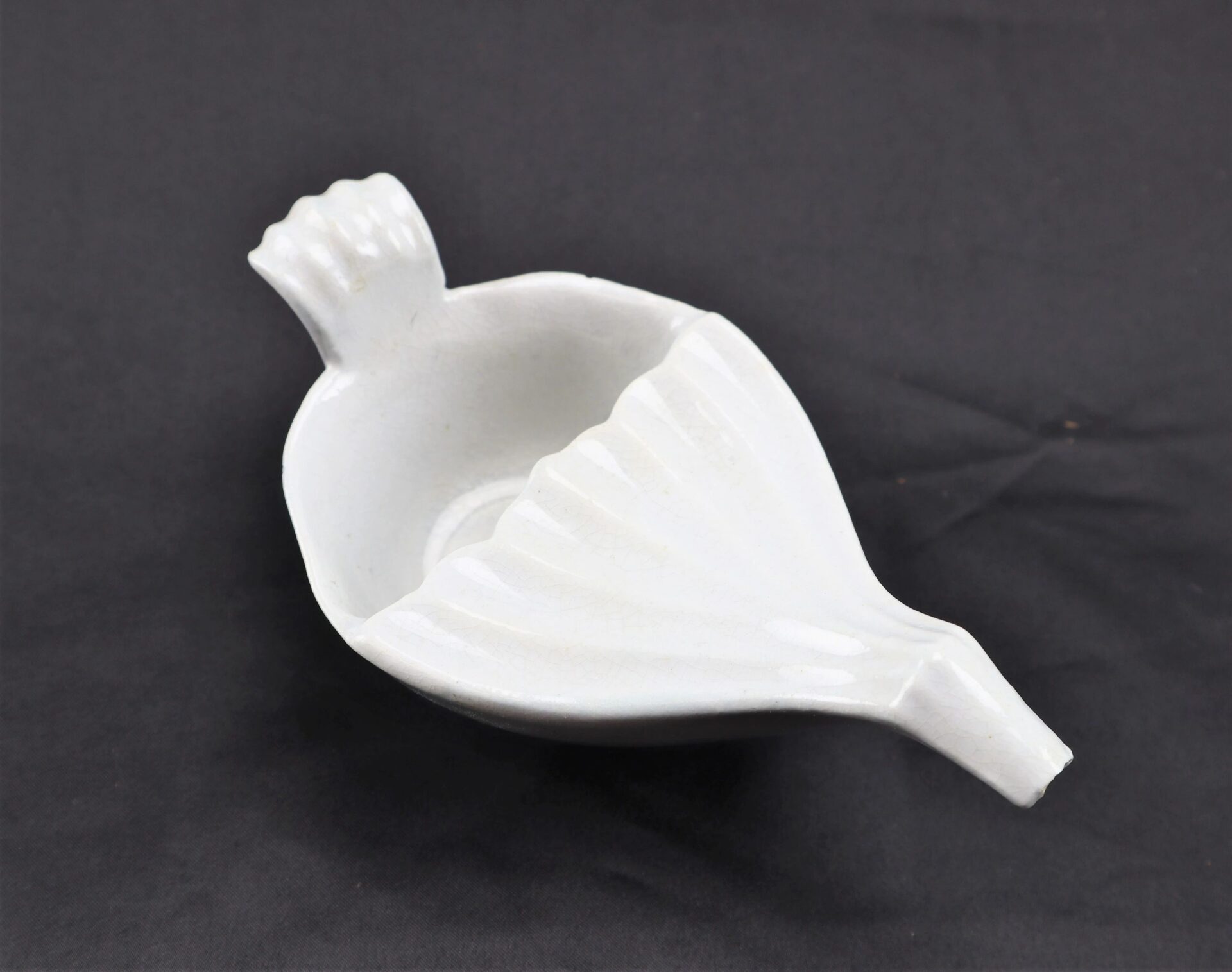Invalid Feeder / SOLD, a white ceramic juicer with handle and spout, shown on a black background.