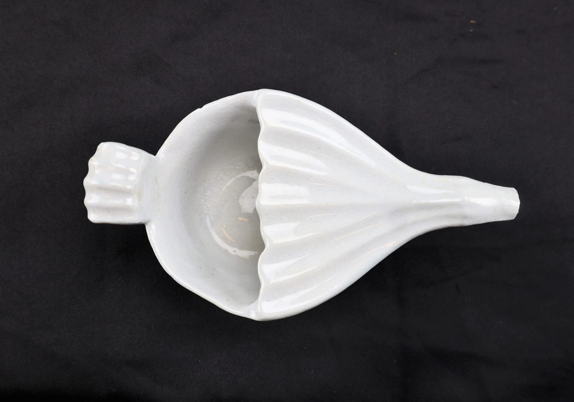 Invalid Feeder / SOLD: A white ceramic citrus juicer with a handle, shown on a black background.