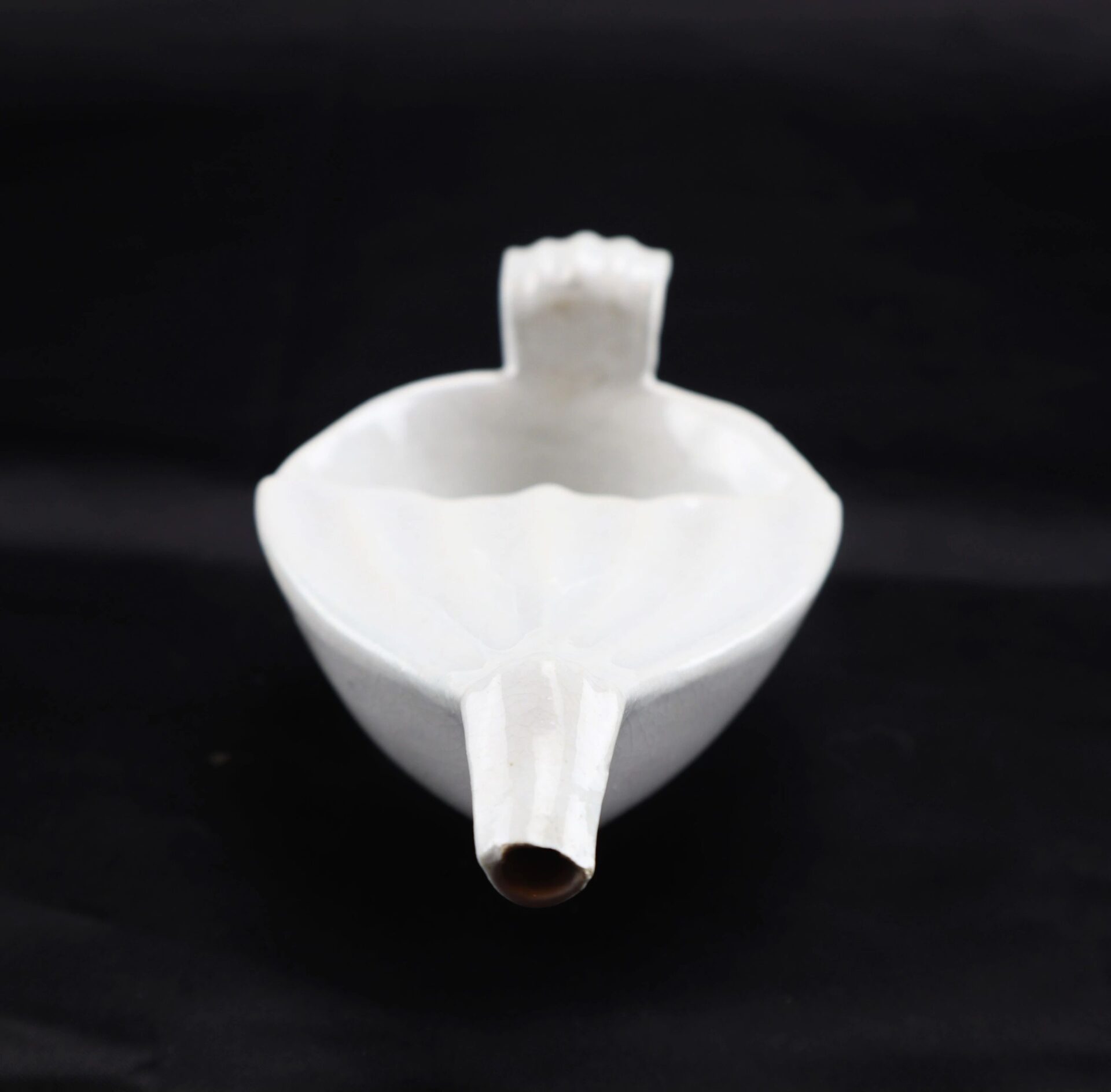 Invalid Feeder bowl with a spout and small handle, shown on a black background.