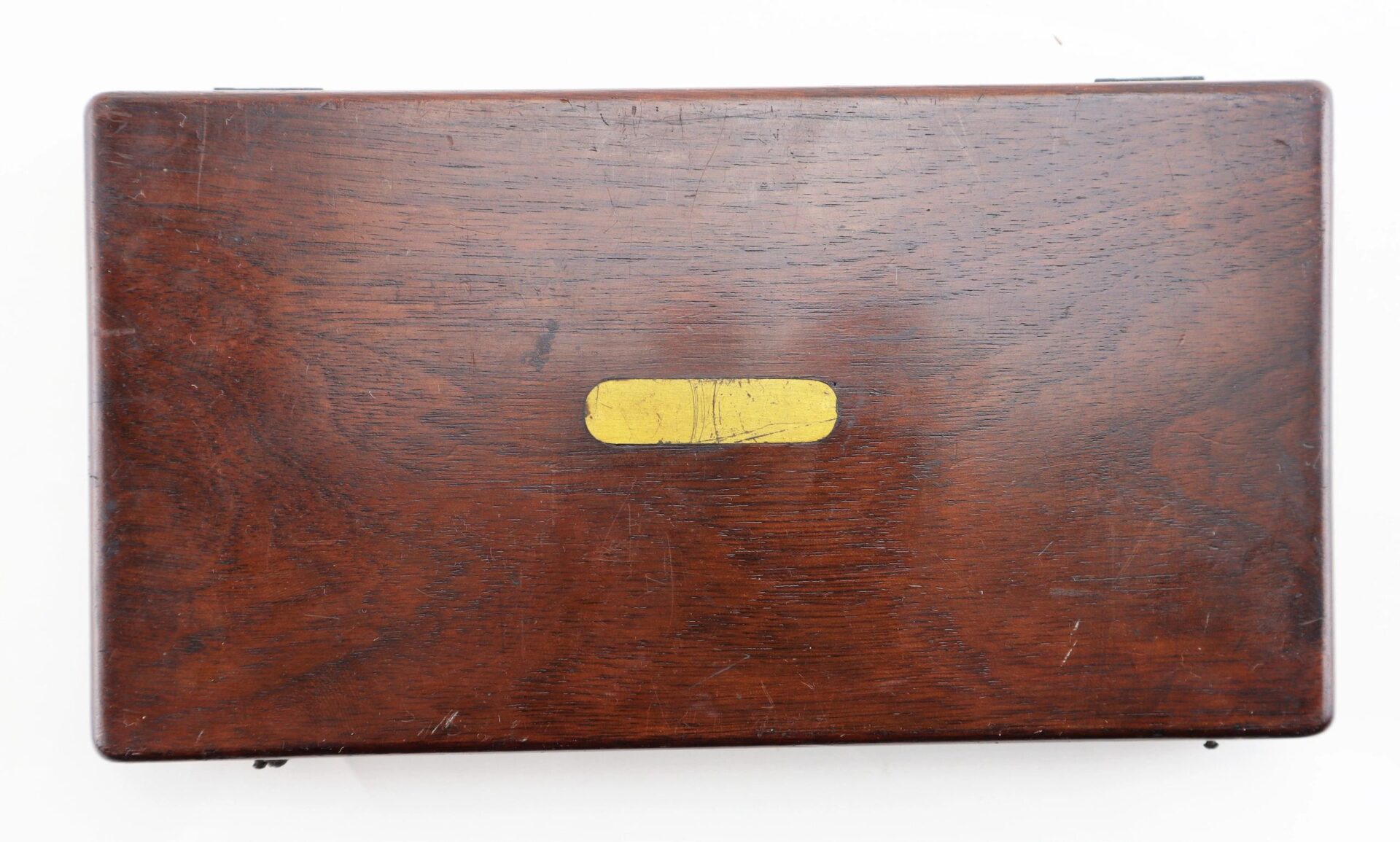 A closed rectangular wooden box with a glossy finish and a small, centered brass plate on the lid for the Civil War Dog / Slave Collar (Sold).