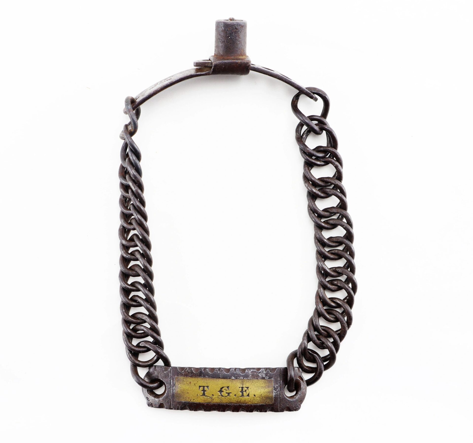 A Civil War dog/slave collar featuring a metal shackle, short chain, and a brass nameplate engraved "T.G.L.," shown against a white background.