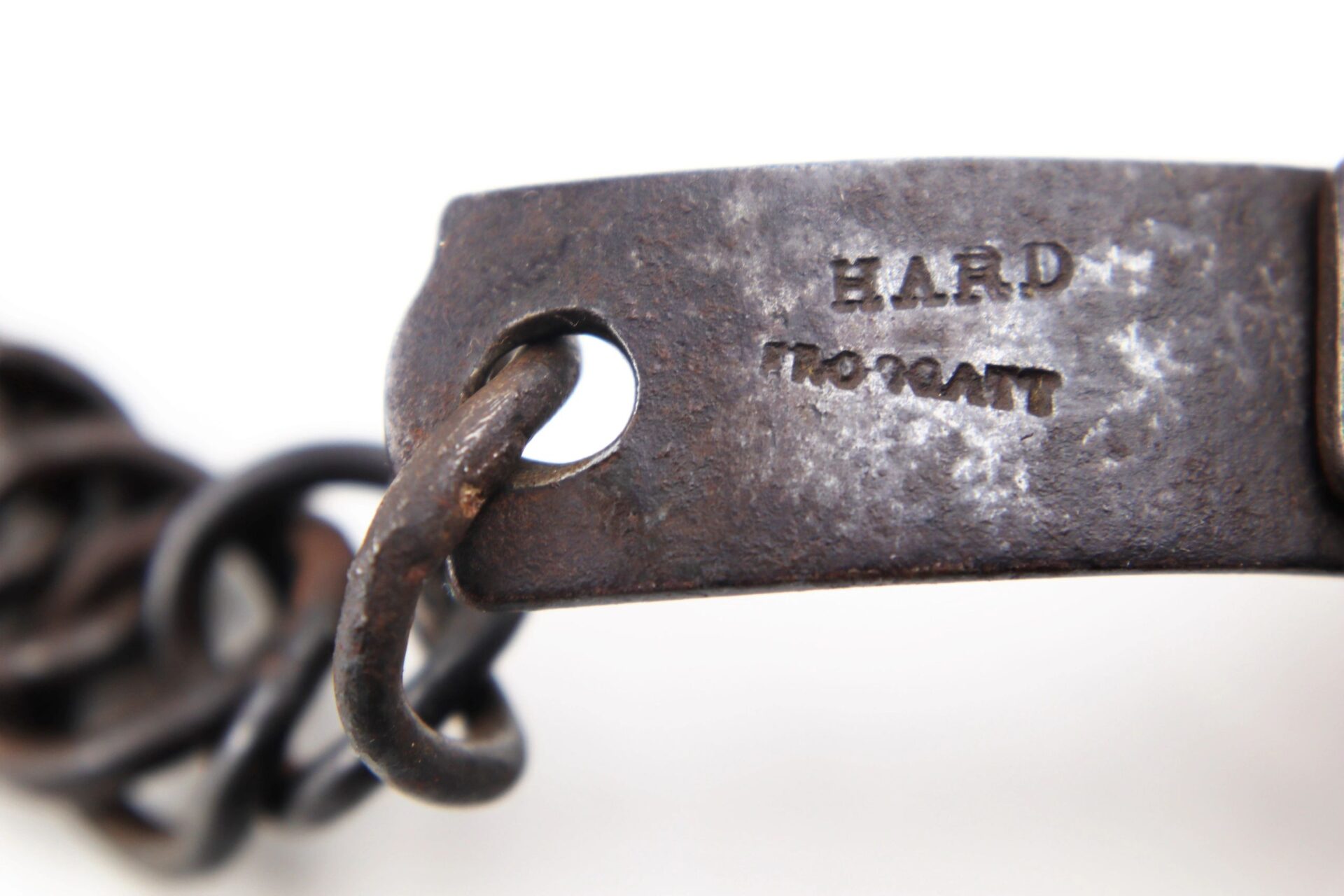 Close-up of a worn metal chain link from a Civil War Dog / Slave Collar stamped with "HARD TO GRANT.