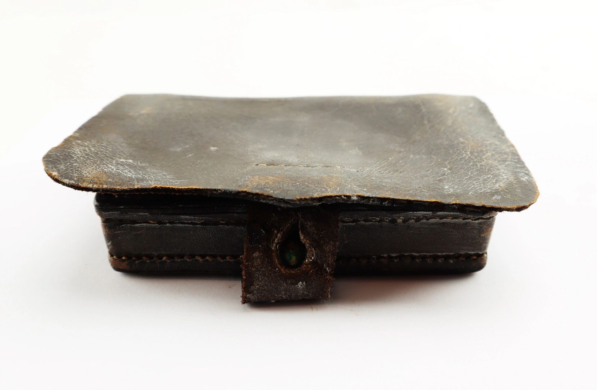 A Civil War Pistol Cartridge Box, rectangular and dark leather with a flap cover and visible stitching, is displayed against a plain white background.
