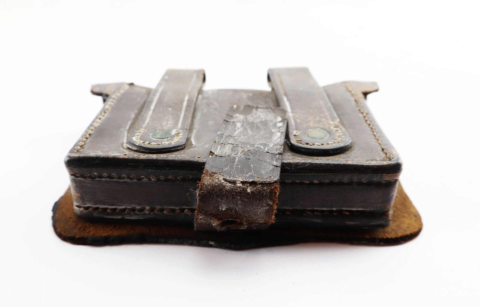 A Civil War Pistol Cartridge Box with visible stitching, metal rivets, a damaged strap, and worn vintage leather is displayed on a white background.