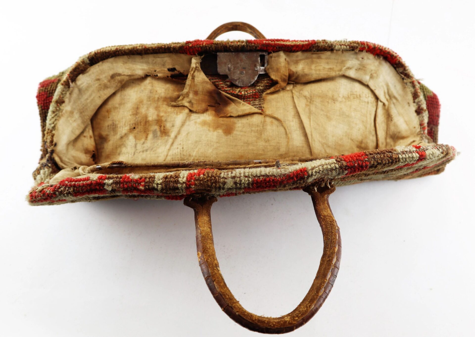 A Civil War “Carpet Bag” with visible handles, worn vintage fabric, and a damaged interior lining is shown open from above. Sold.
