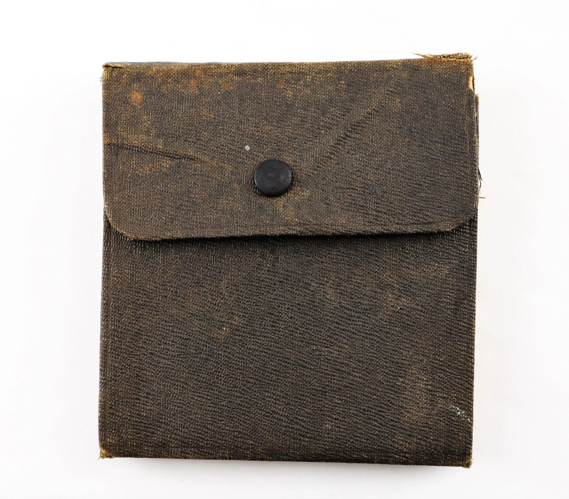 A weathered canvas pouch with a single black snap button and frayed edges, used to hold the Abraham Lincoln Centennial Medal.