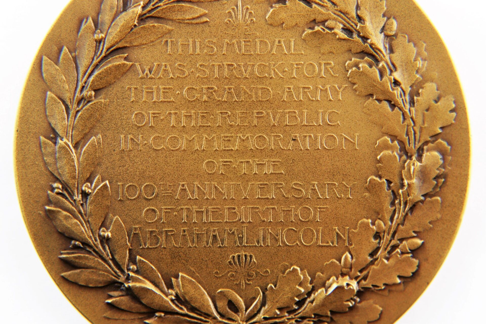 An Abraham Lincoln Centennial Medal, sold, features engraved text commemorating Lincoln’s 100th anniversary for the Grand Army of the Republic and is encircled by a laurel wreath.