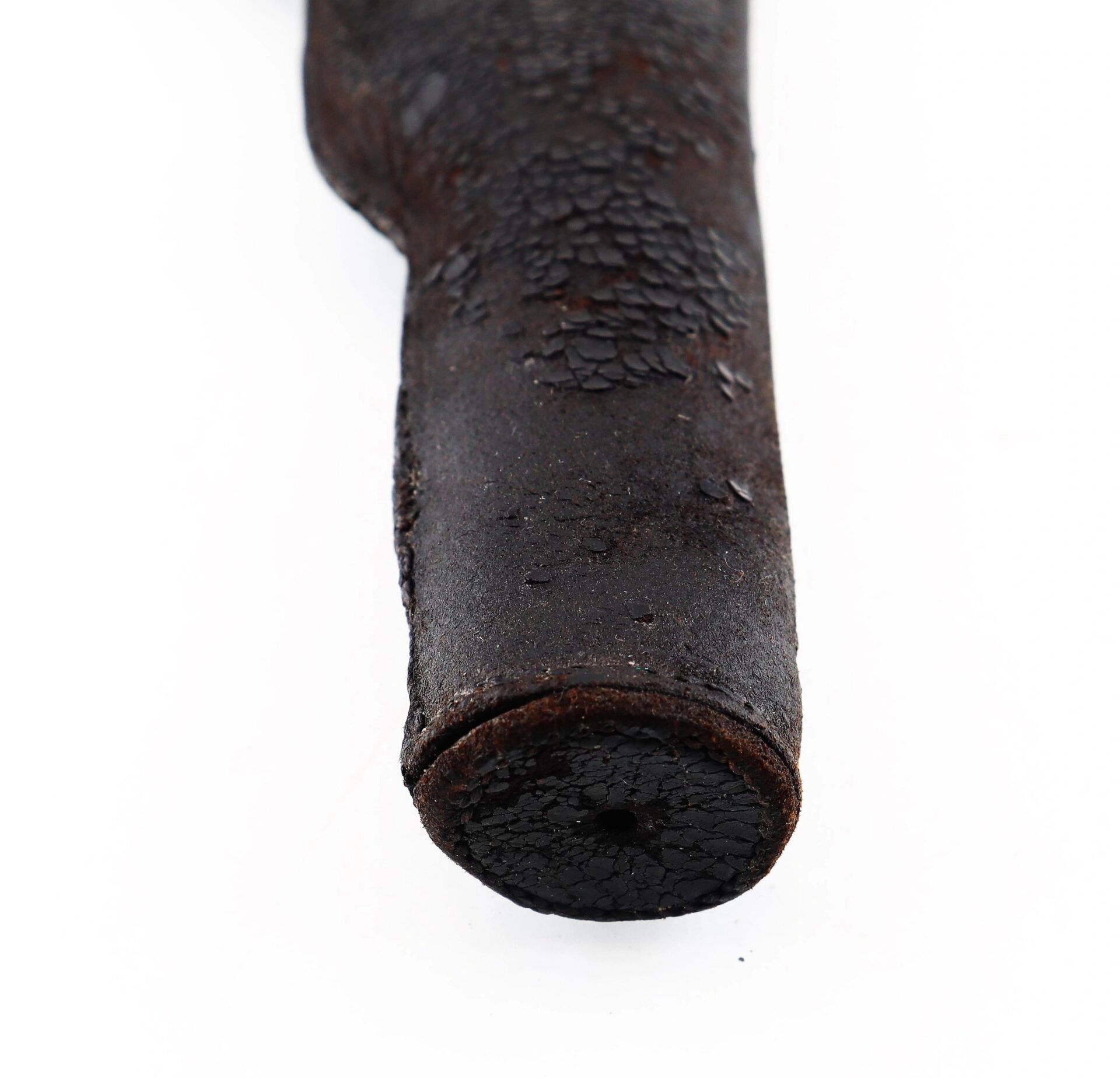 Close-up of a Colt Dragoon Holster (SOLD), showing its cylindrical shape, cracked and textured surface, with a circular end, set against a white background.