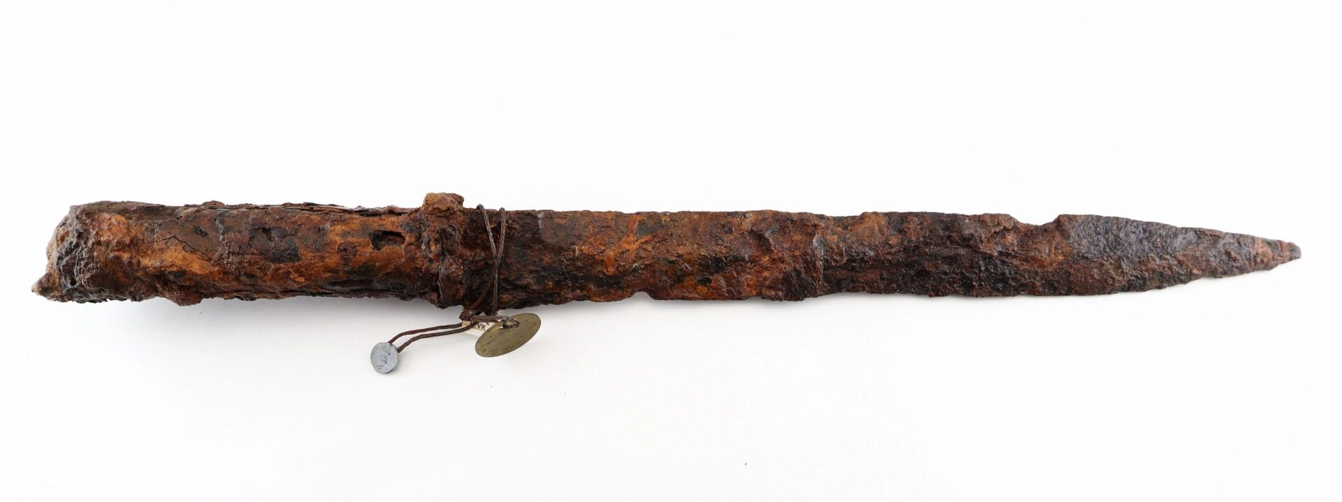 A rusty, ancient Confederate “Bridle-Cutter” Pike with a corroded blade and handle, featuring two small identification tags attached with wire.
