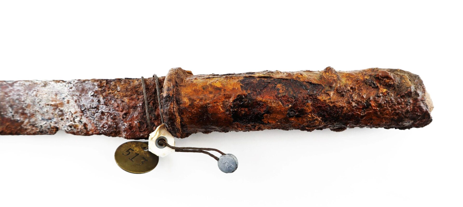 A heavily rusted and corroded Confederate “Bridle-Cutter” Pike with a tag attached, photographed on a white background.