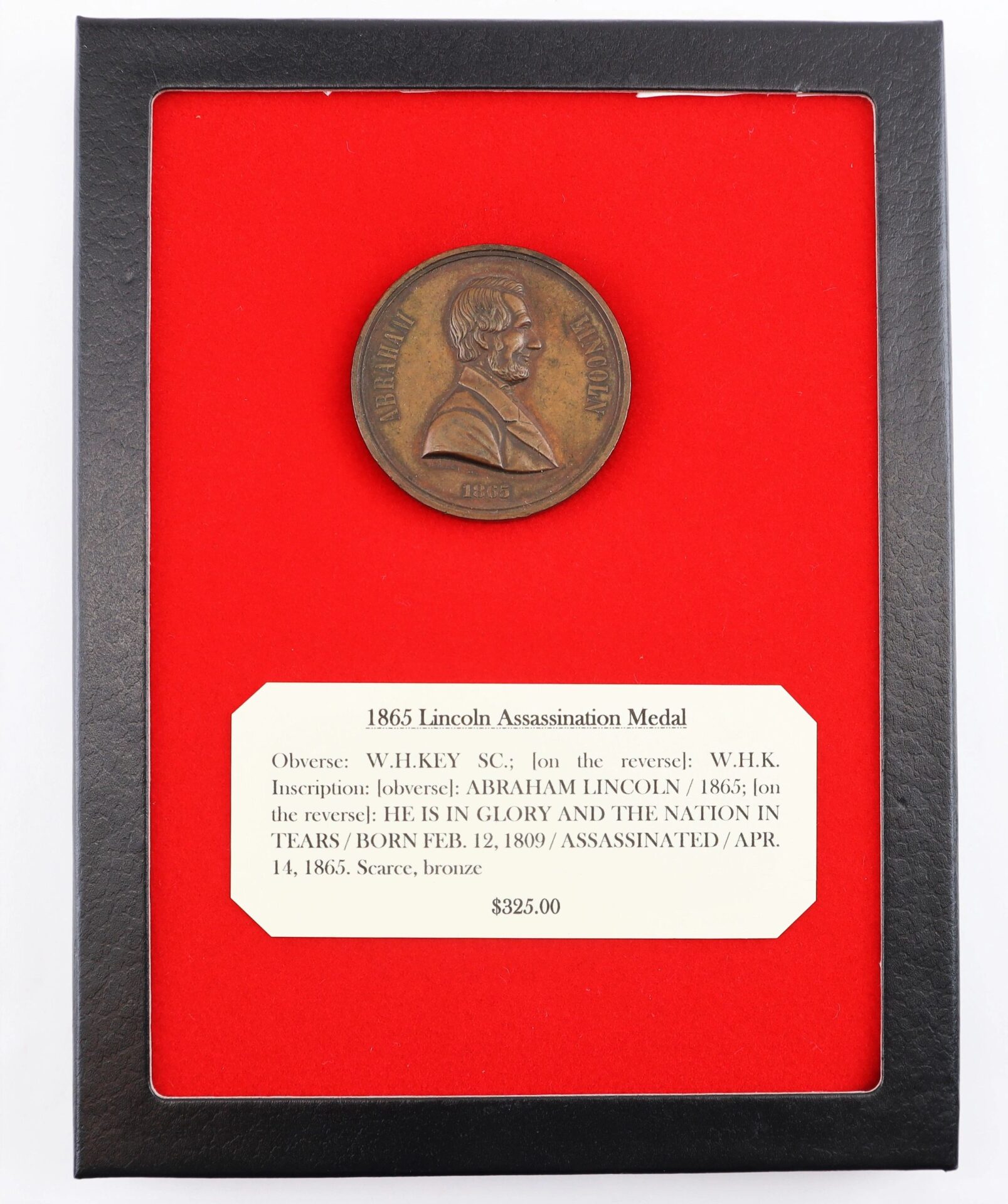 A framed "Lincoln 1865 Lincoln Assassination Medal / SOLD" is showcased on red backing, with a label providing its description, price, and historical details.