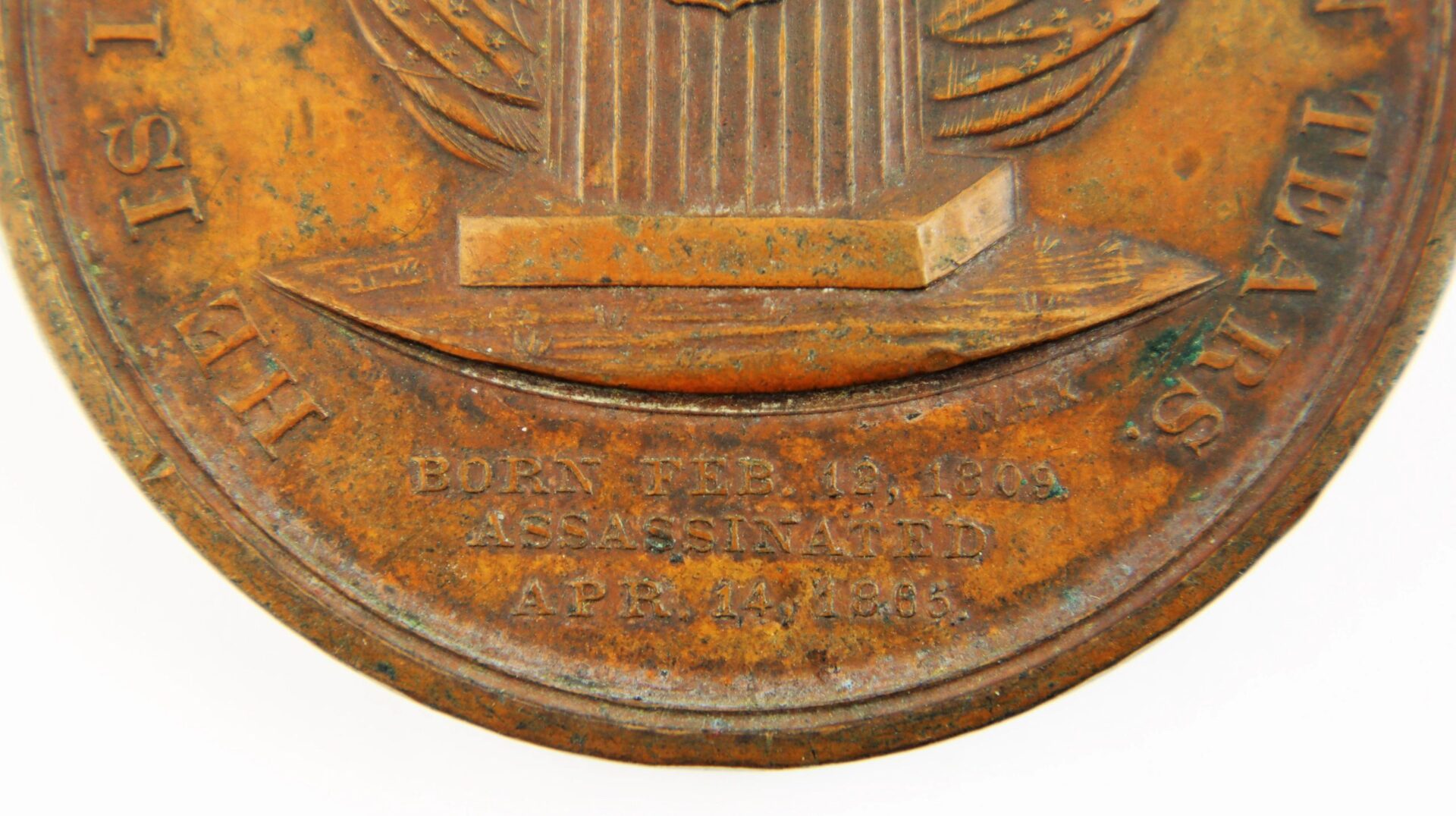 Close-up of the Lincoln 1865 Lincoln Assassination Medal, a bronze medallion engraved with: “BORN FEB. 12, 1809 ASSASSINATED APR. 14, 1865.” / SOLD.