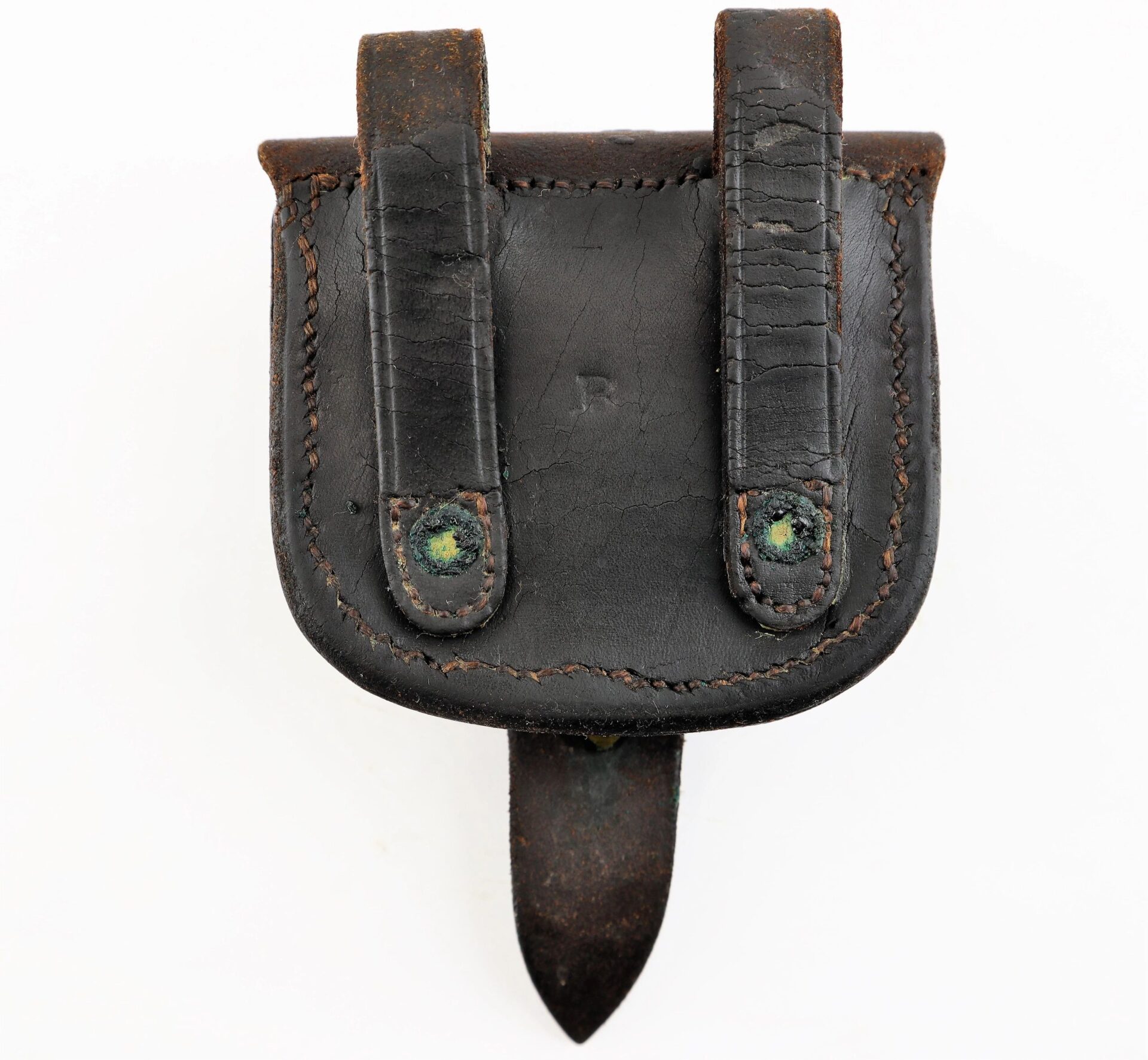 A Civil War Percussion Cap Box with two belt loops and a pointed flap, made of worn black leather and showing signs of age and use.