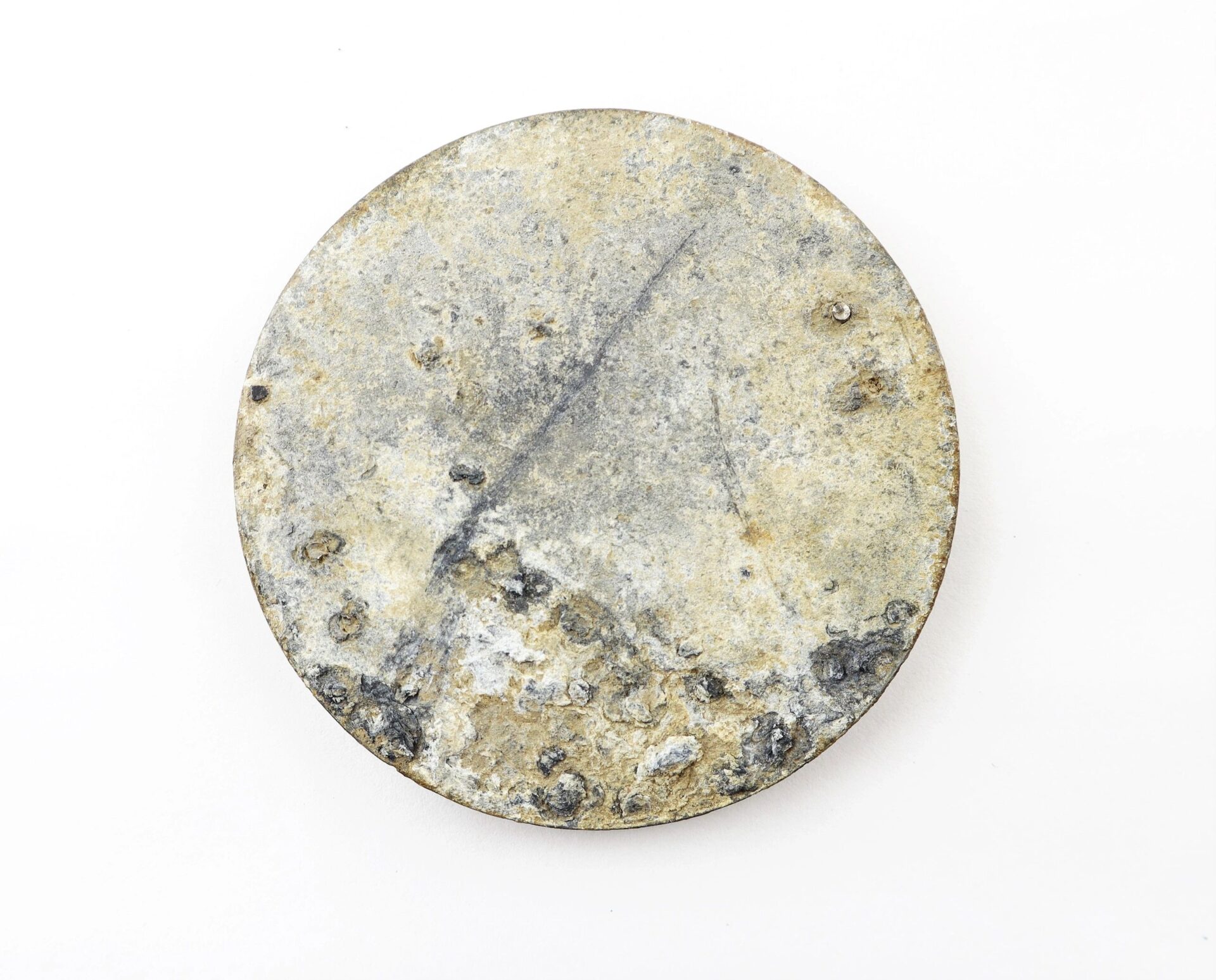 An excavated U.S. Eagle Breast Plate with a corroded, round metal surface showing rough texture and visible oxidation, displayed against a plain white background.