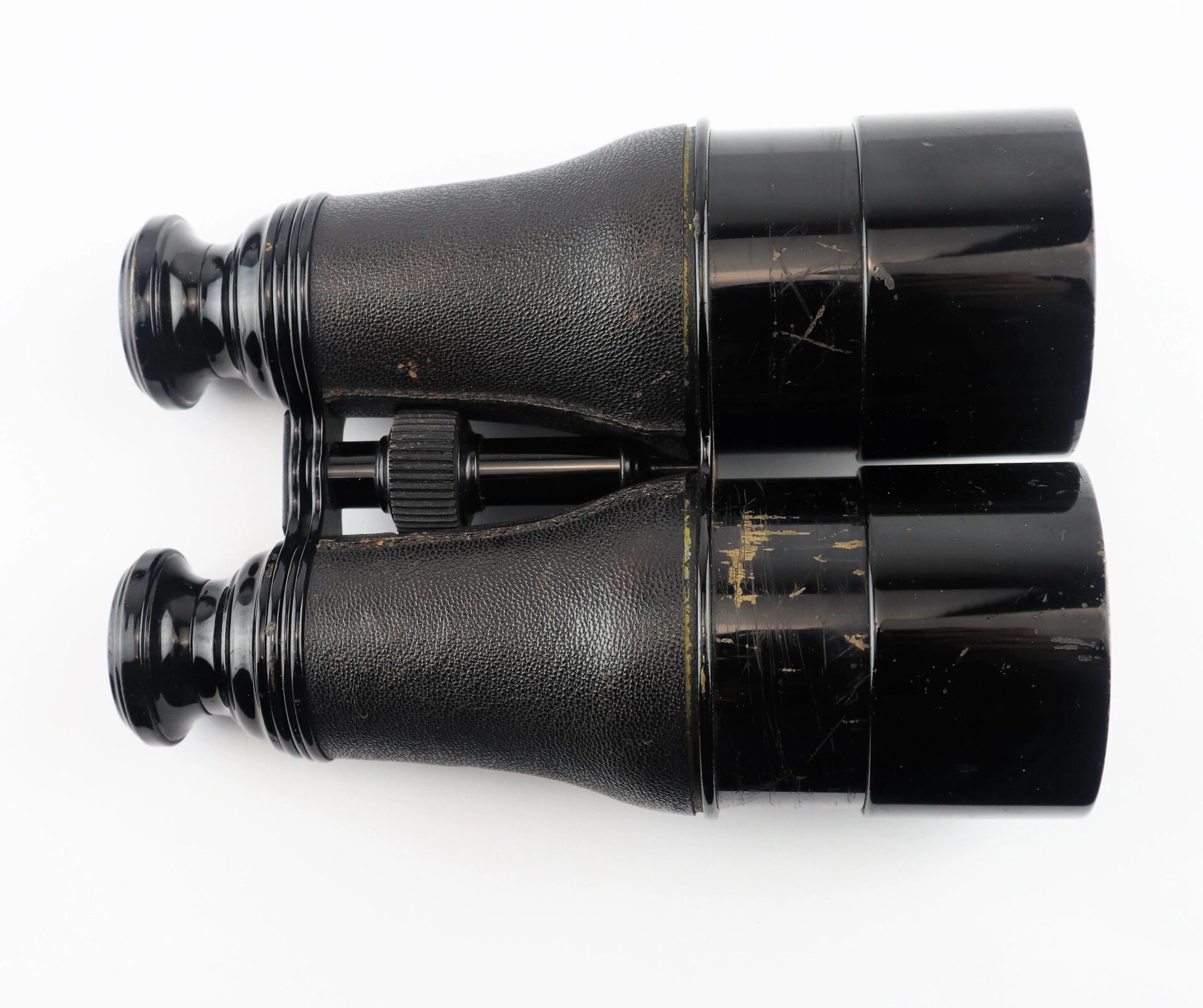 A pair of Civil War Field Glasses with visible wear and scratches on the body, shown with their case against a white background.