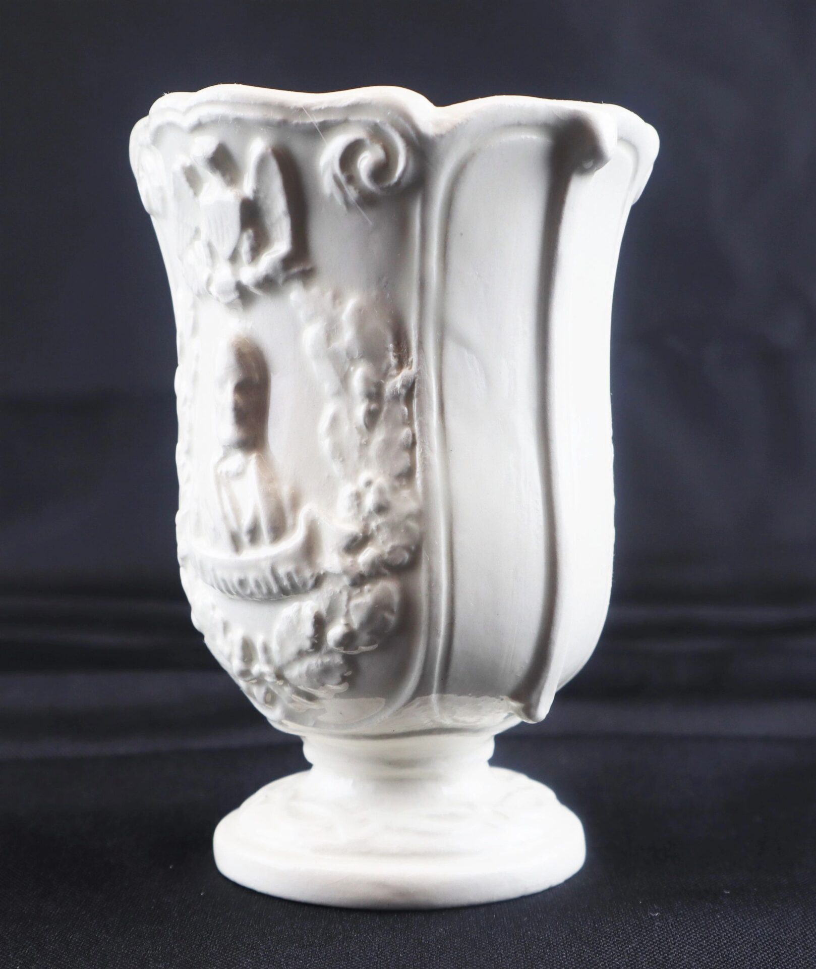 Civil War Vintage Abraham Lincoln Stoneware Vase featuring decorative embossed patterns and a pedestal base, displayed against a black background.