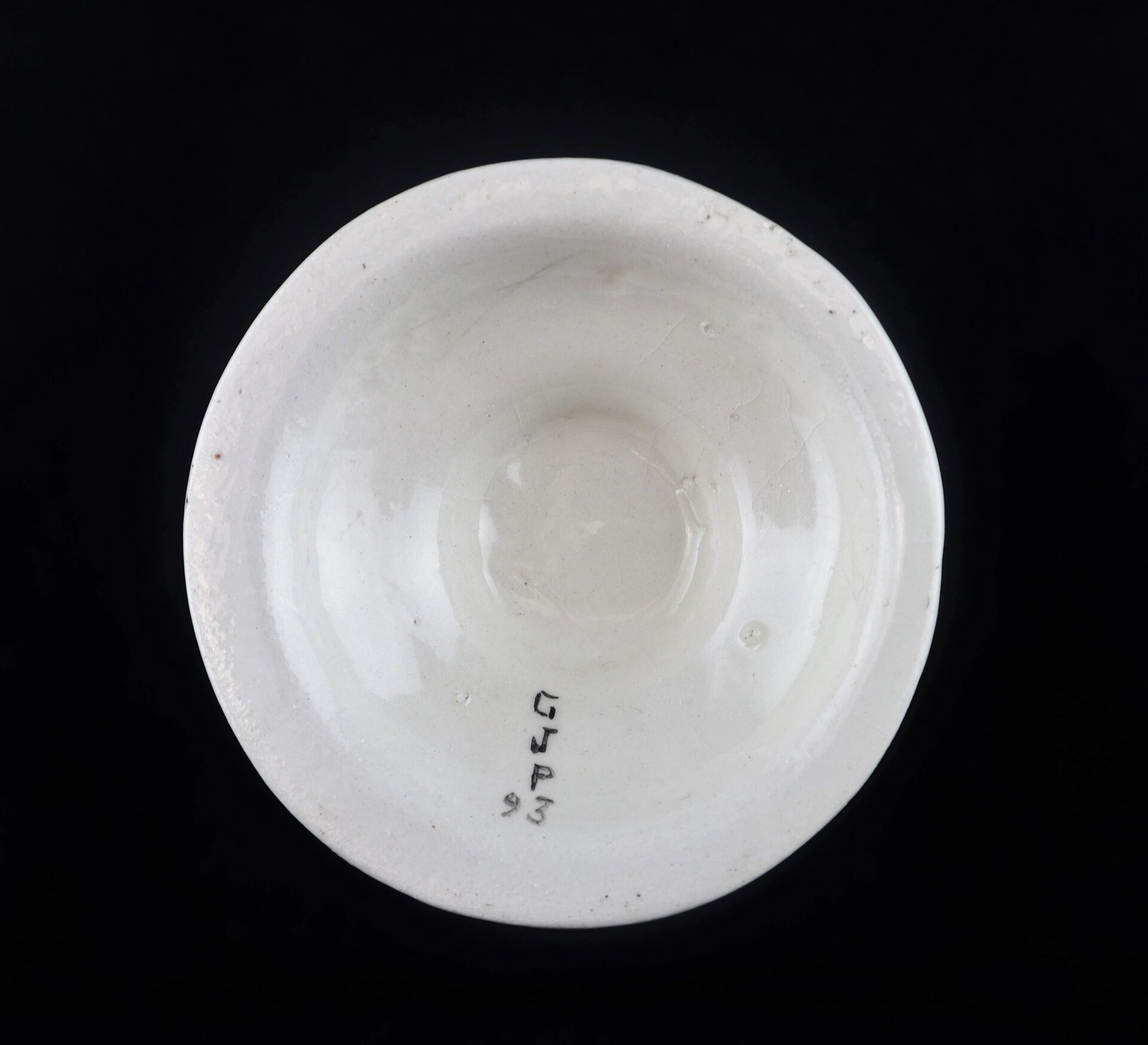 A Civil War Vintage Abraham Lincoln Stoneware Vase viewed from above, showing handwritten "GJJP3 93" inside, set against a black background.