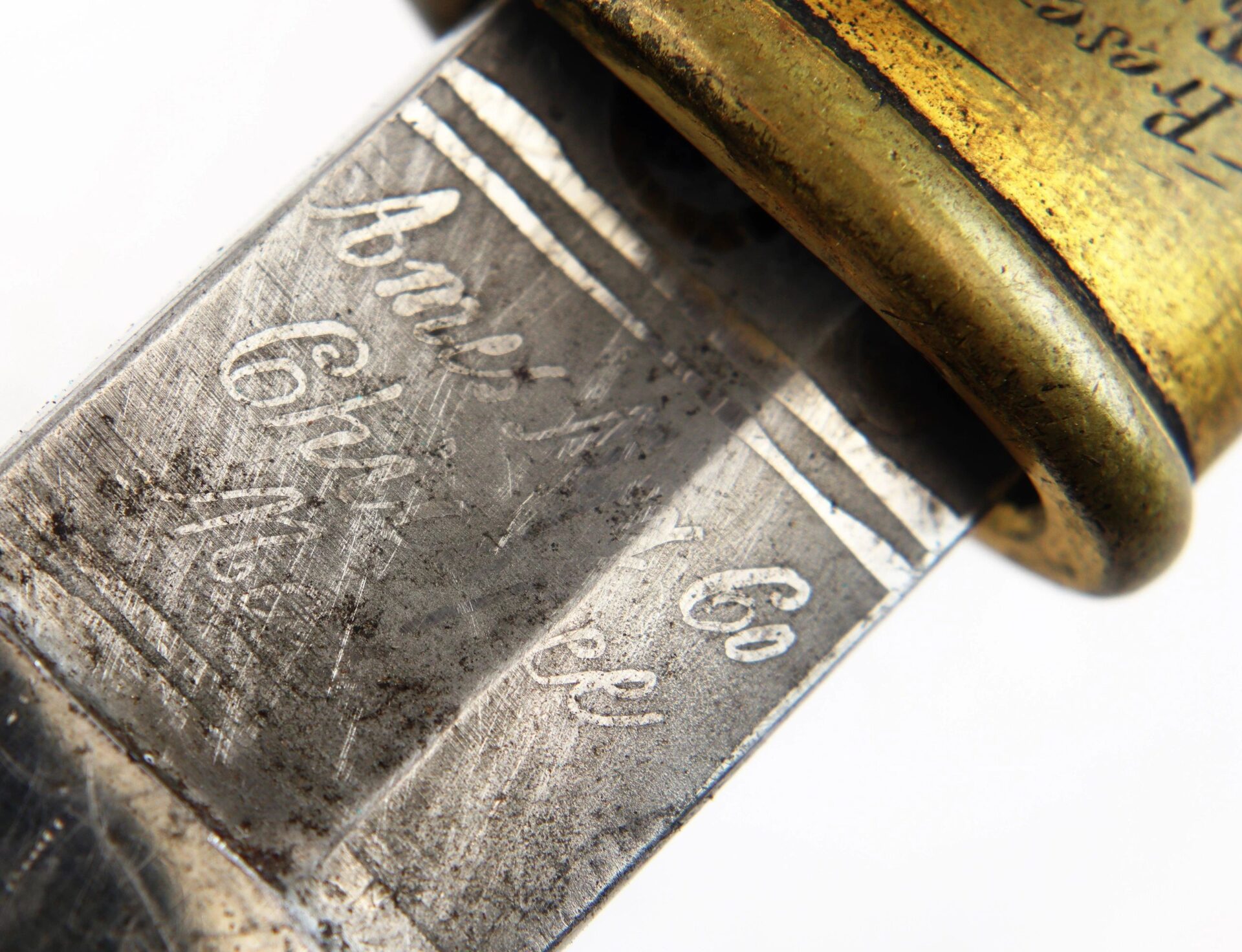 Close-up of the 1850 Foot Officer’s Sword presented to Fitch Taylor Birdsall, 20th Connecticut Infantry, featuring an engraved metal blade and brass guard with visible wear and tarnish.