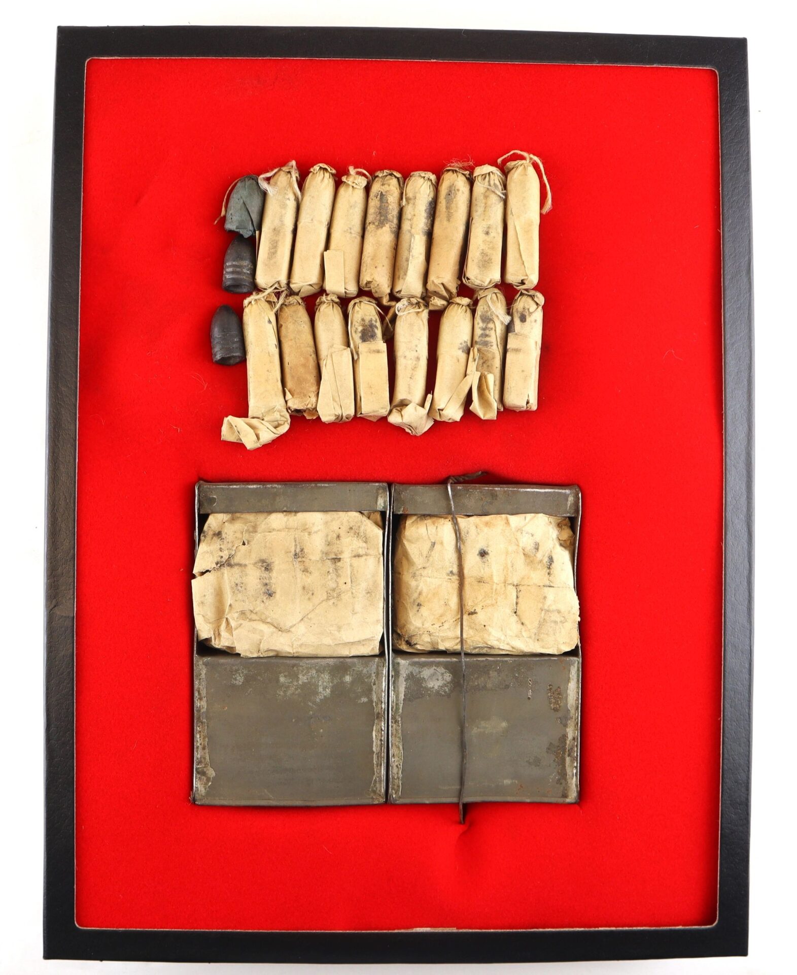 A Complete Cartridge Box (SOLD) featuring 12 aged rolled parchment scrolls and two metal-bound books, all arranged against a red background.