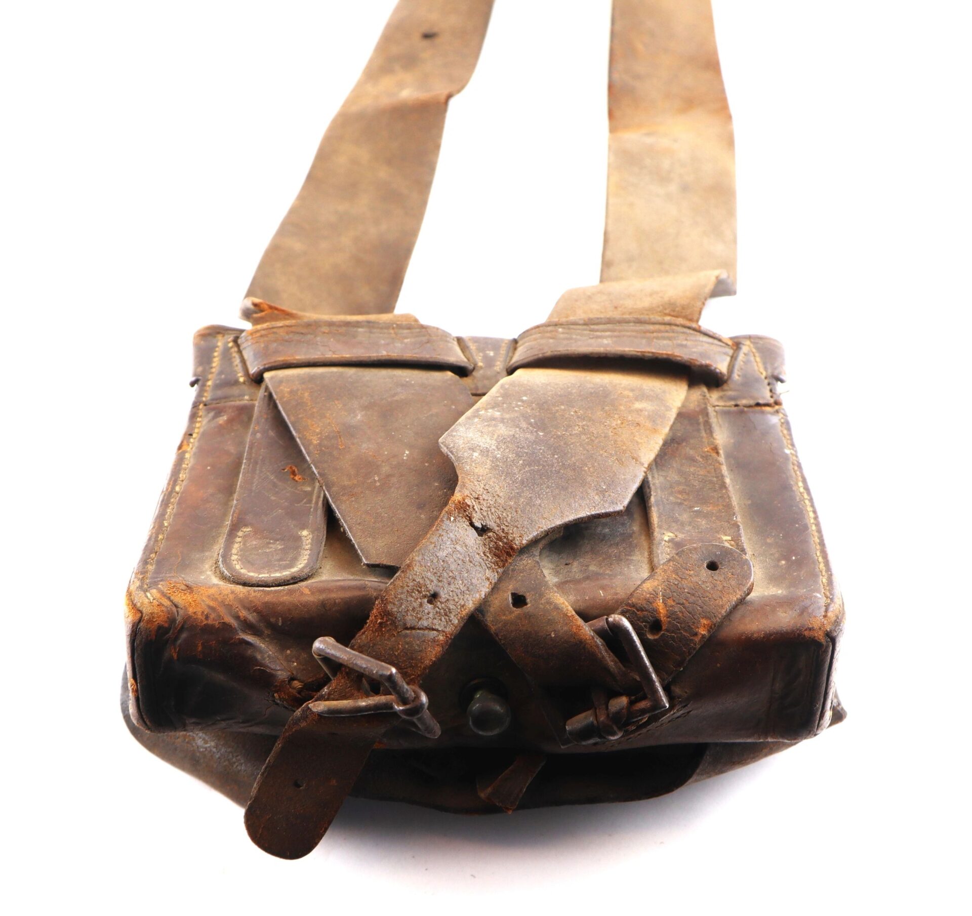 A vintage Complete Cartridge Box with a shoulder strap and buckled flap, featuring visible signs of age and use, rests against a white background.