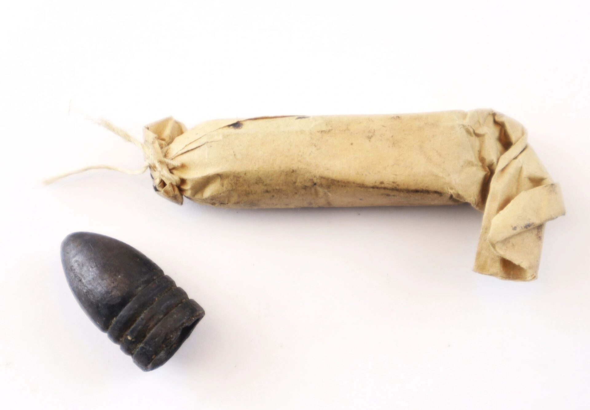 A Complete Cartridge Box (SOLD), containing a black Civil War-era bullet and a wrapped paper cartridge, is displayed on a white background.