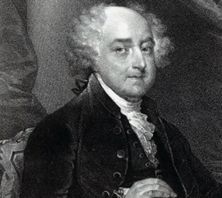 Black and white portrait of President John Adams, an older man with white hair in a dark coat and white cravat, seated facing forward. He is shown wearing the Button Worn by President John Adams.