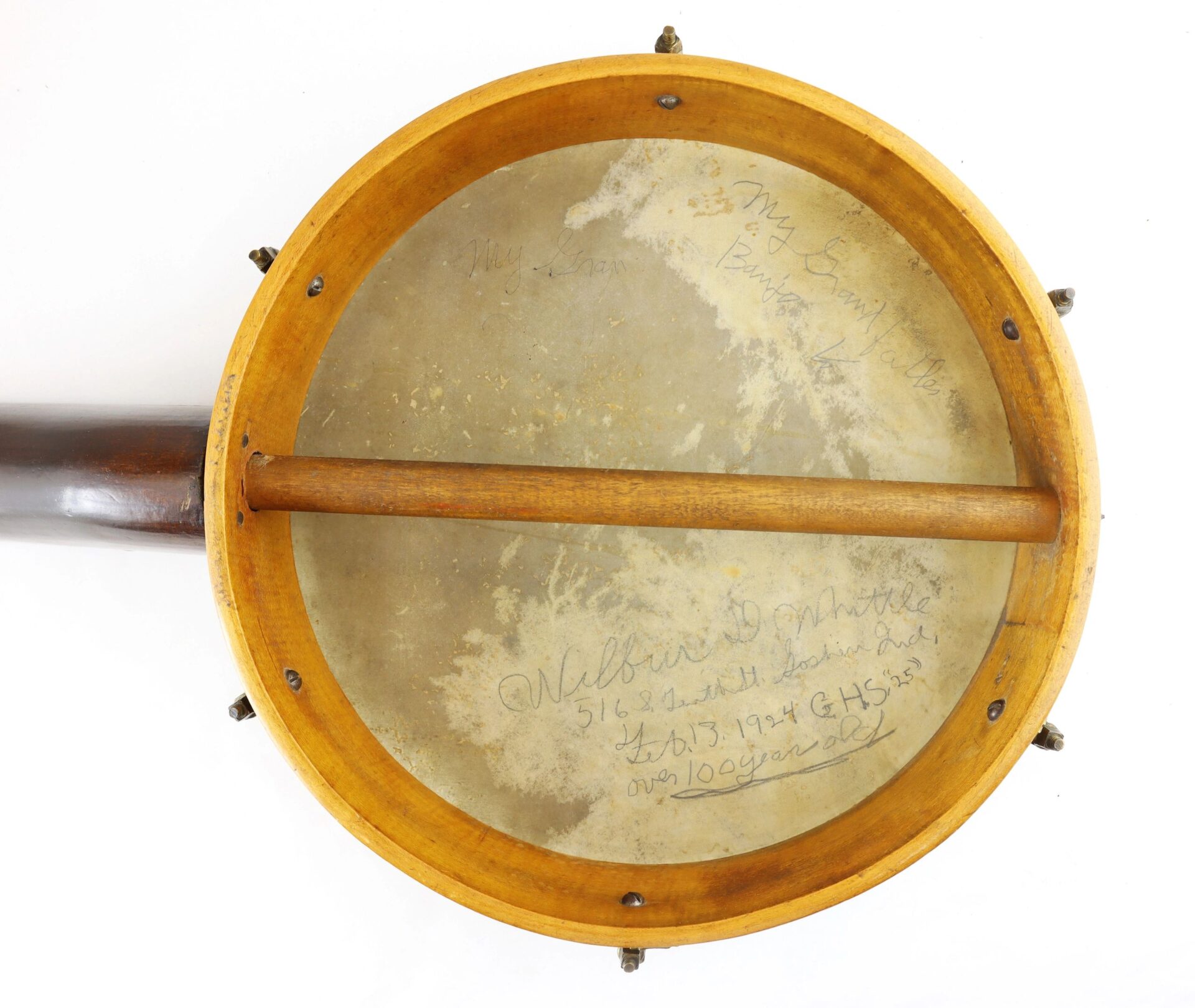 A close-up of a Civil War Era Banjo (SOLD) showing its vintage head with handwritten notes and signatures, plus visible wooden rim and dowel stick.