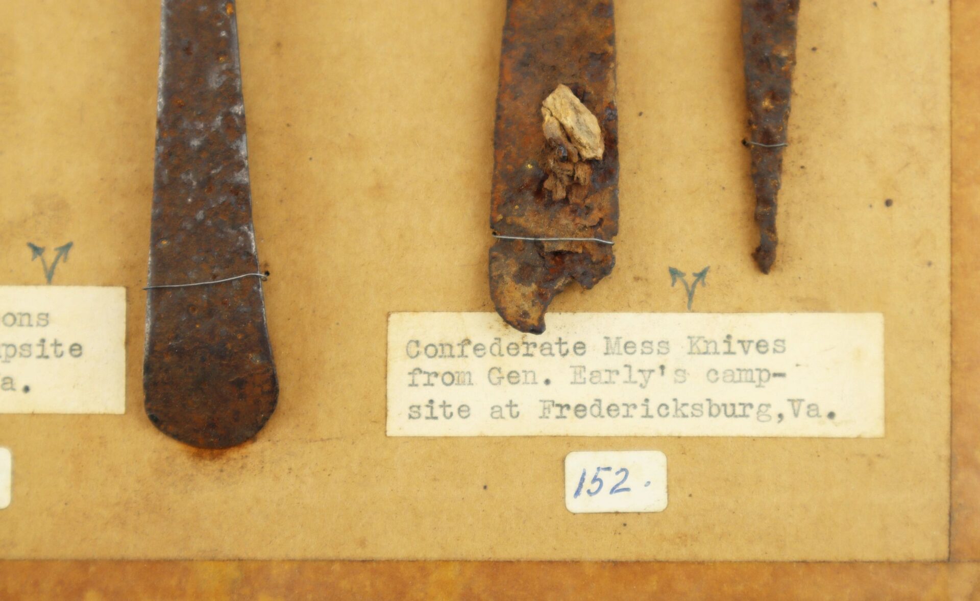Close-up of a display label reading “Collection of Relic Civil War Utensils / Sold,” with rusty knife fragments mounted above the label.