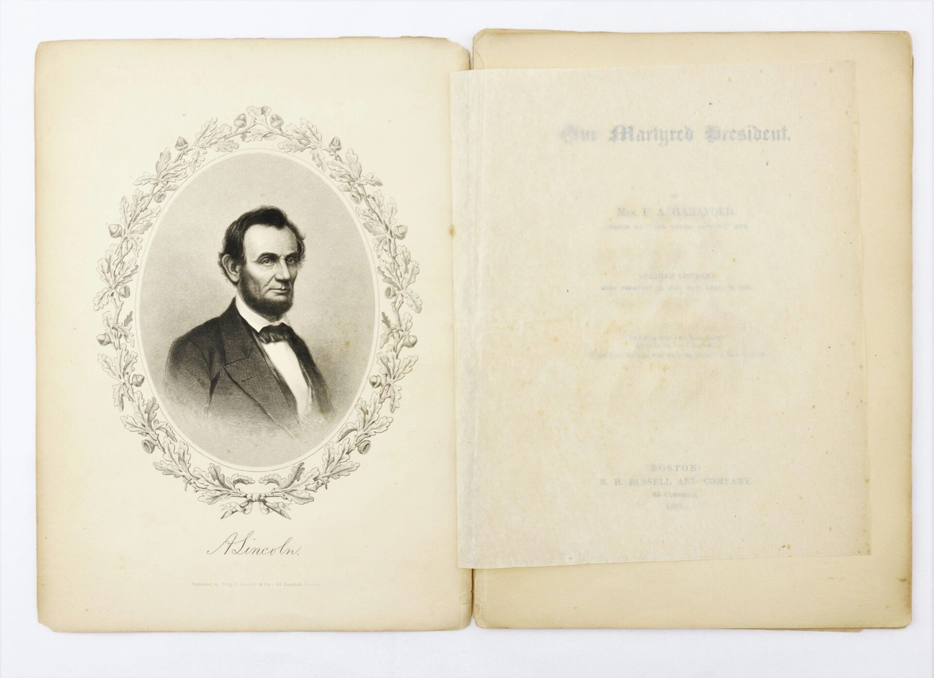 An open copy of "1865 Our Martyred President by Phoebe Anne Hanaford / SOLD" shows a black and white portrait of Abraham Lincoln on the left page and faded text on the right.