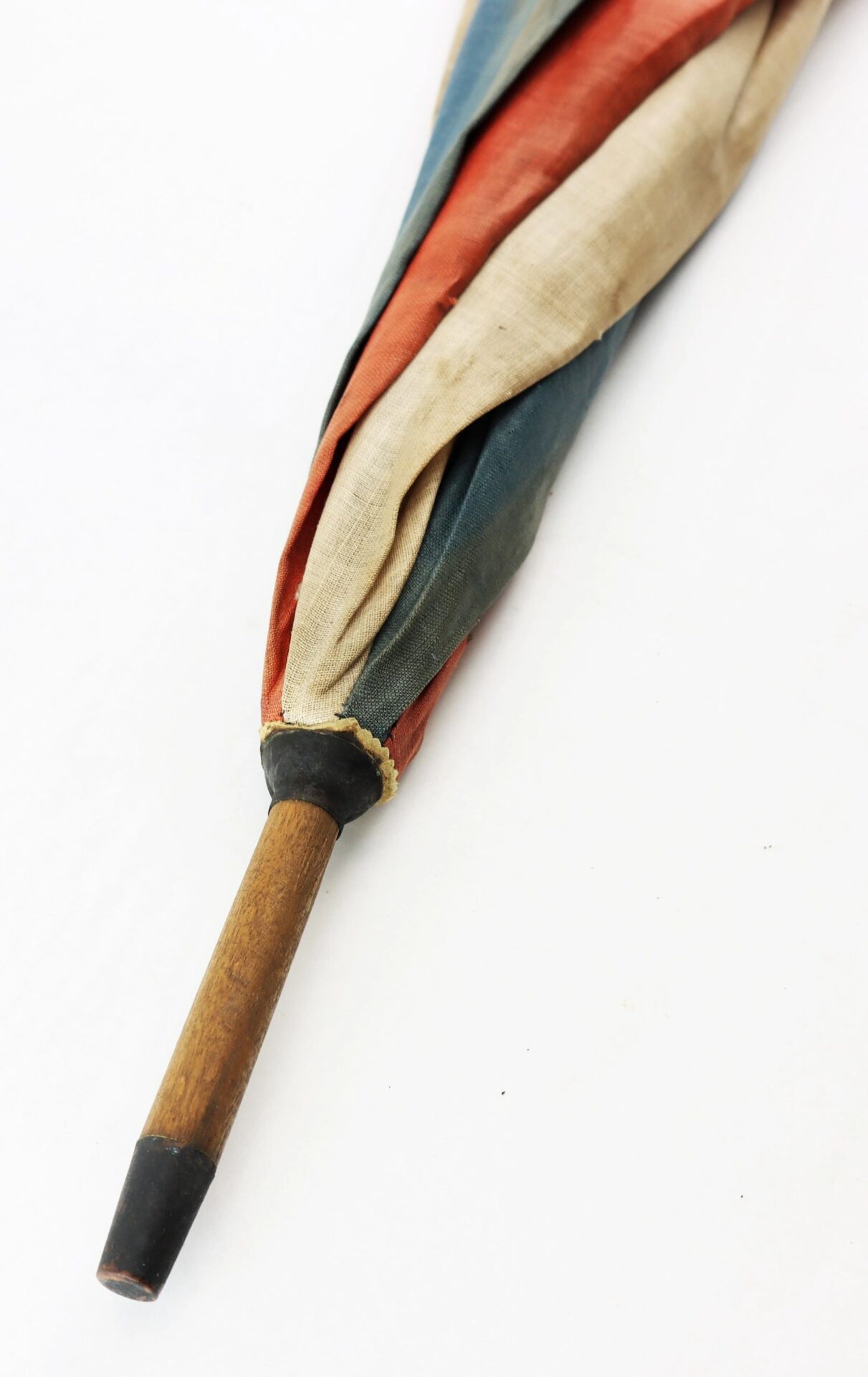The Patriotic Parasol, featuring a wooden handle and multicolored fabric, is shown closed against a white background.