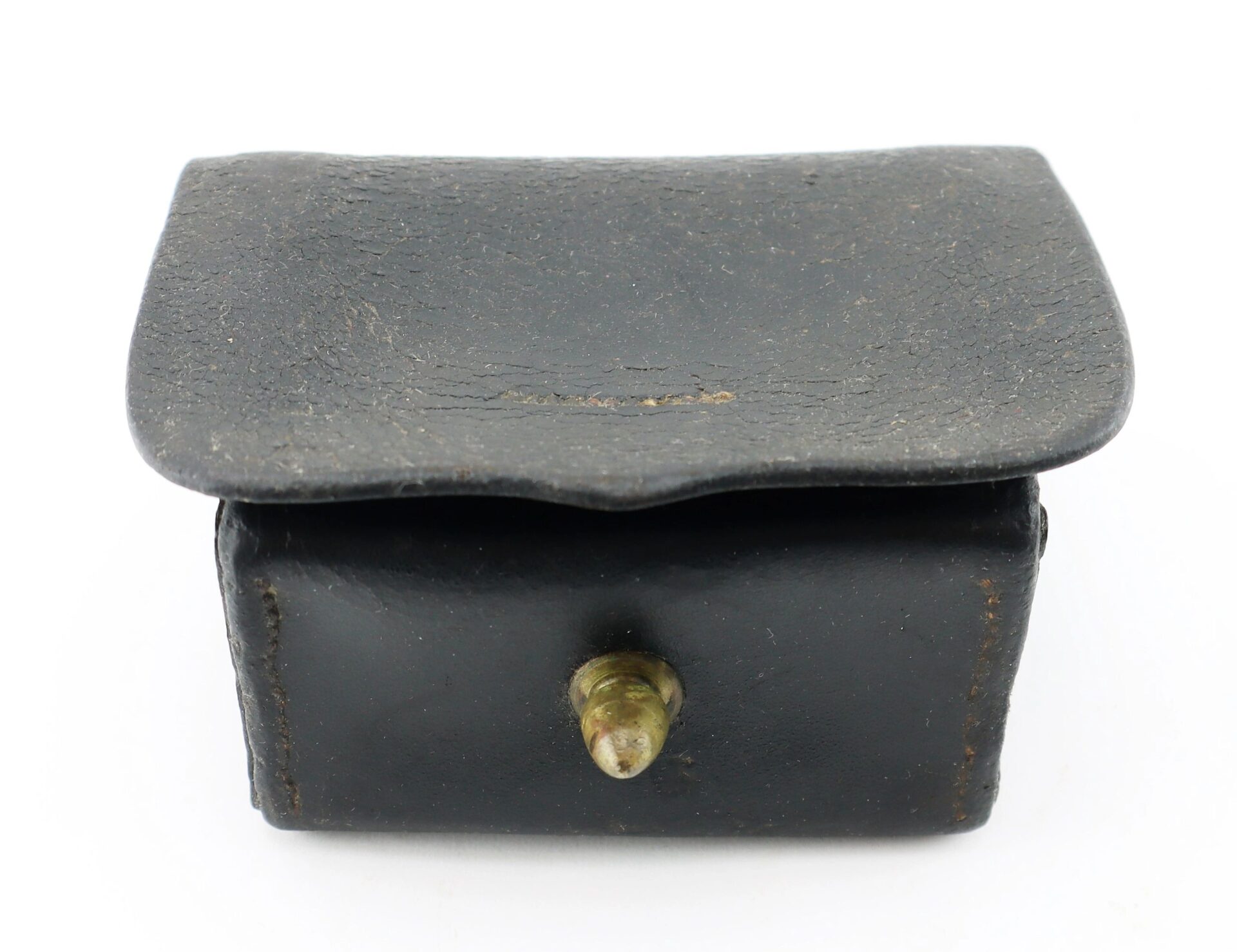 A Civil War Navy Fuse Box, small and rectangular, made of black leather with a flap lid and brass knob on the front.
