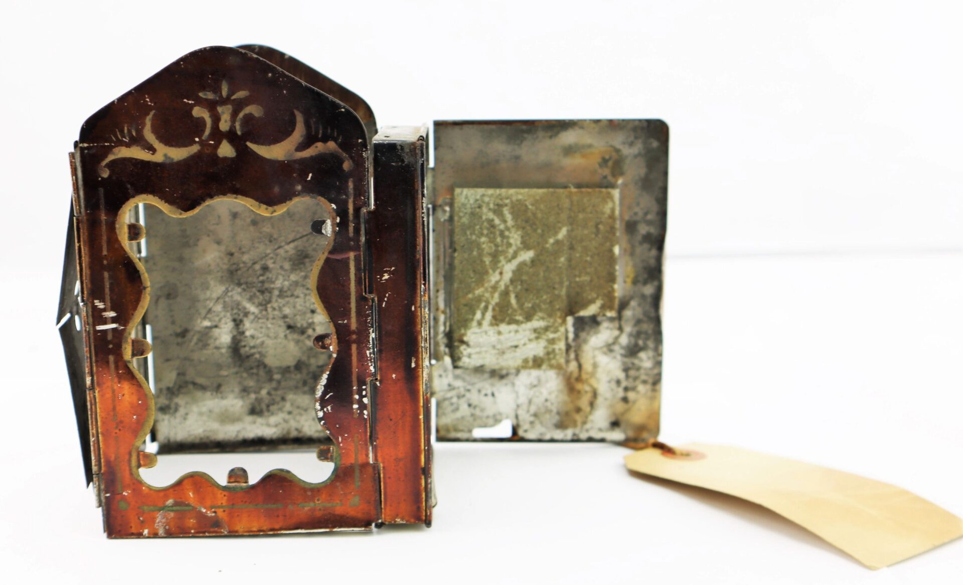 A Civil War Era Minor’s Patent Lantern with an open door and tan tag attached, showcasing a weathered interior.