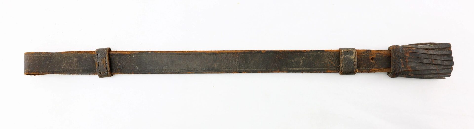 A Civil War Cavalry Enlisted Saber Knot, featuring a worn leather strap with a loop at one end and several leather fringes at the other, displayed flat on a white background.