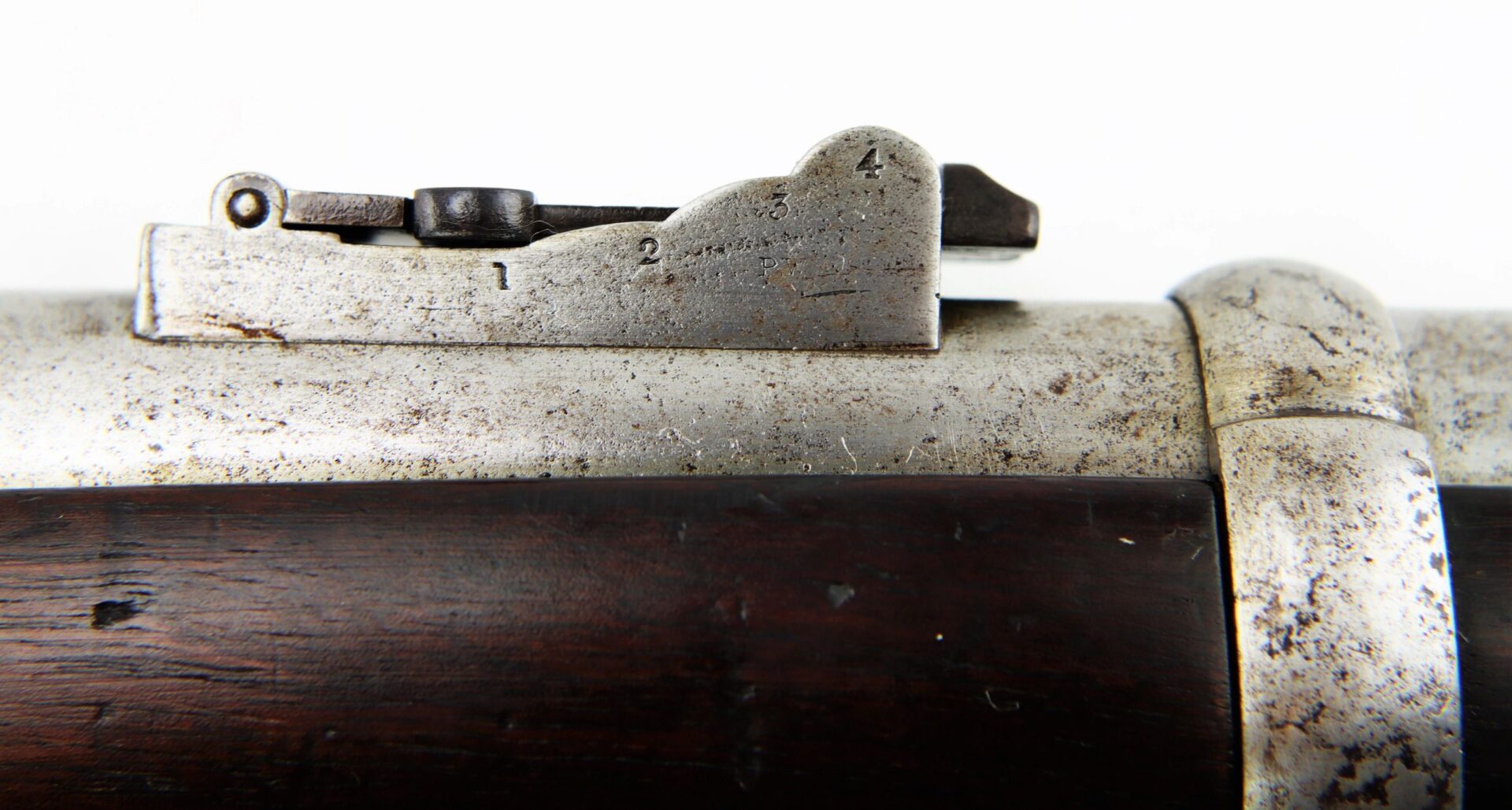 Close-up of a metal rear sight with numbered markings on the barrel of a Commercial Enfield Rifle, shown against a white background.