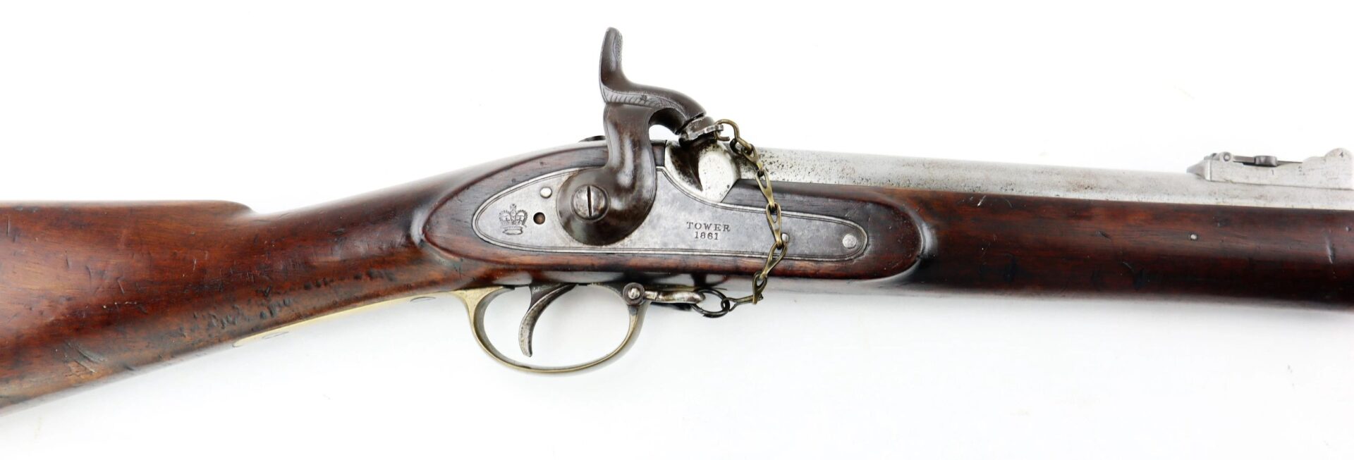 A Commercial Enfield Rifle, a vintage muzzle-loading firearm with a wooden stock and metal lock marked "Tower 1862," is displayed from the side against a white background.