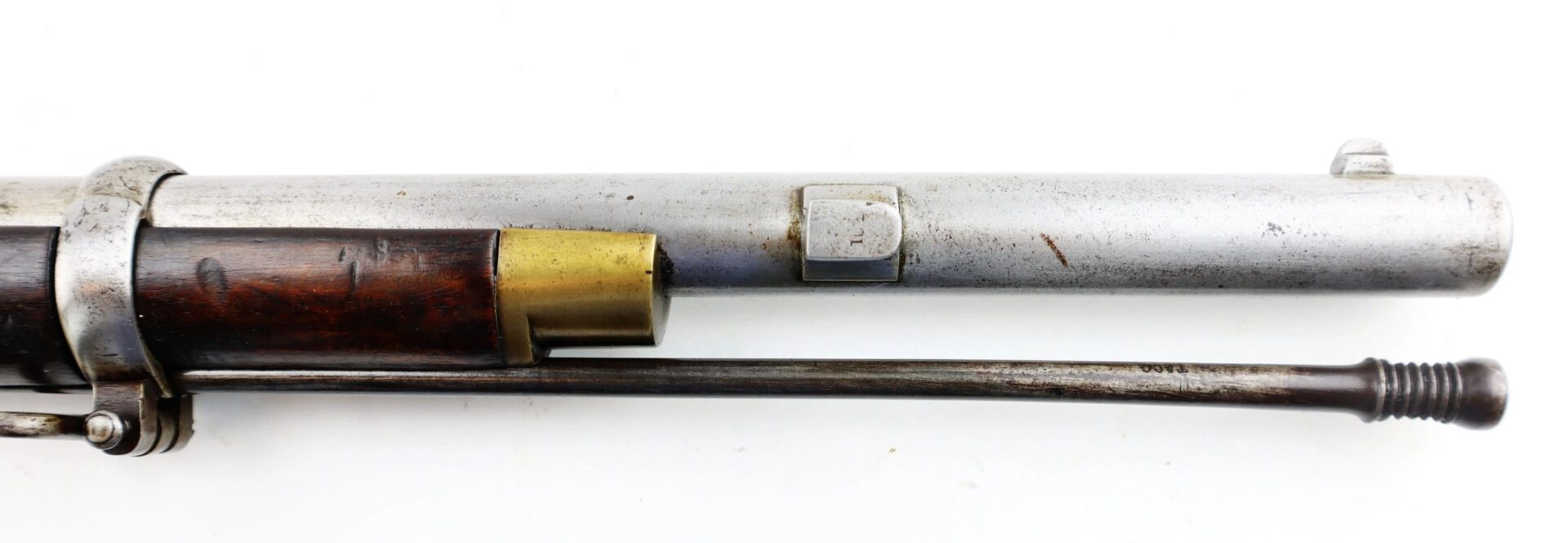 Close-up of the barrel and wooden stock of a Commercial Enfield Rifle, featuring a metal cleaning rod and a brass detail near the breech.