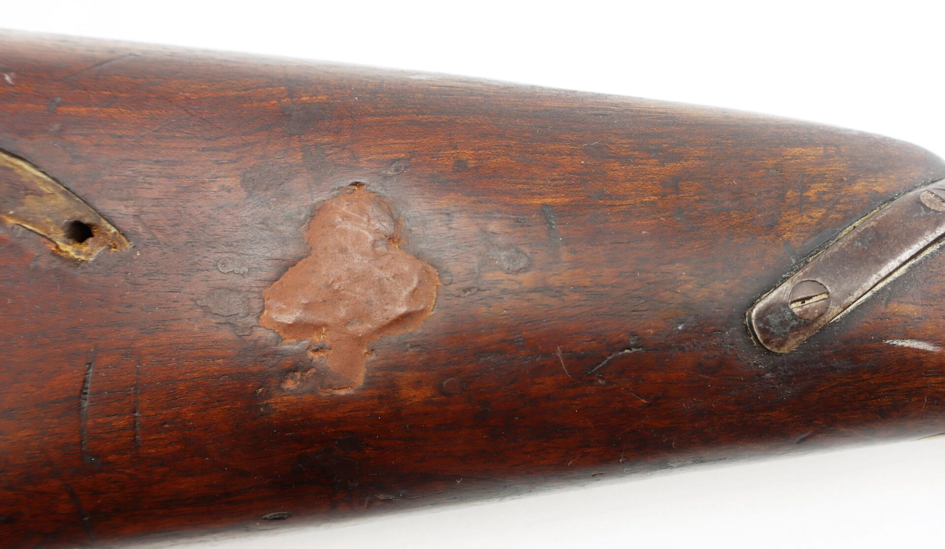 Close-up of a worn wooden stock with patched area and metal hardware on a Confederate 1863 Dated Enfield Altered to a Cavalry Carbine.
