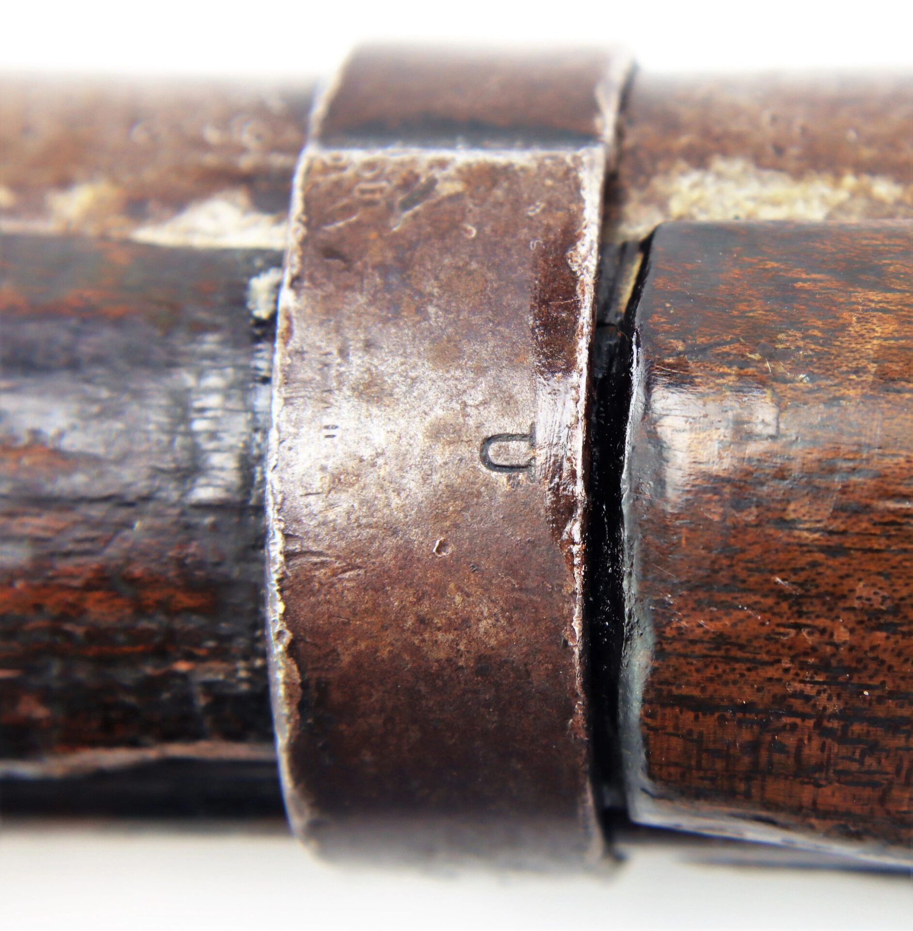 Close-up of a metal band on a worn wood Confederate 1863 Dated Enfield Altered to a Cavalry Carbine, showing scratches and age.