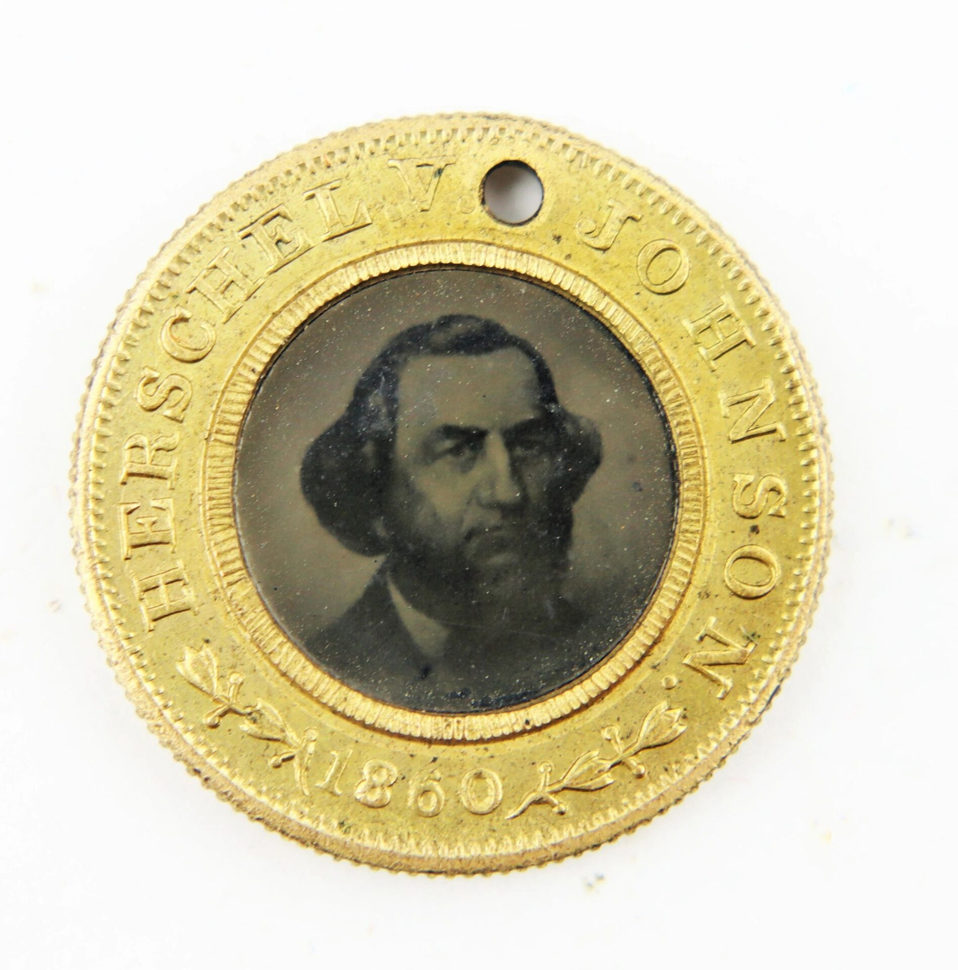 A round brass Stephen Douglas/Herschel Johnson 1860 campaign token featuring a man's portrait in the center with "HERSCHEL V JOHNSON 1860" engraved around the edge.