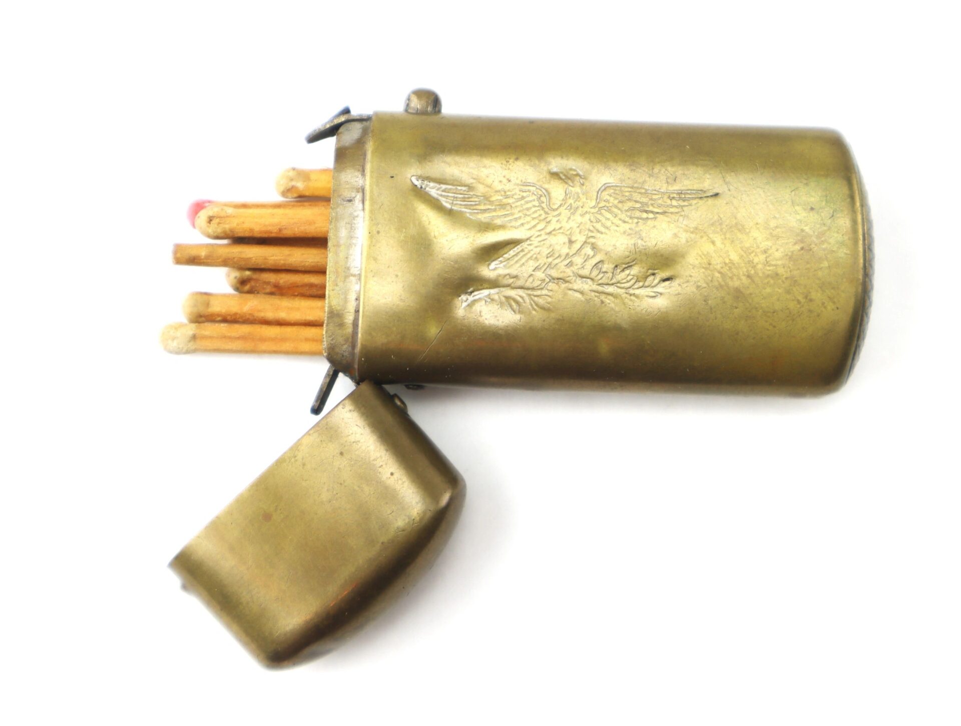 The Civil War Era Patriotic Match Safe is a brass case with a hinged lid, engraved with an eagle design, and holds several wooden matches, including one with a red tip.