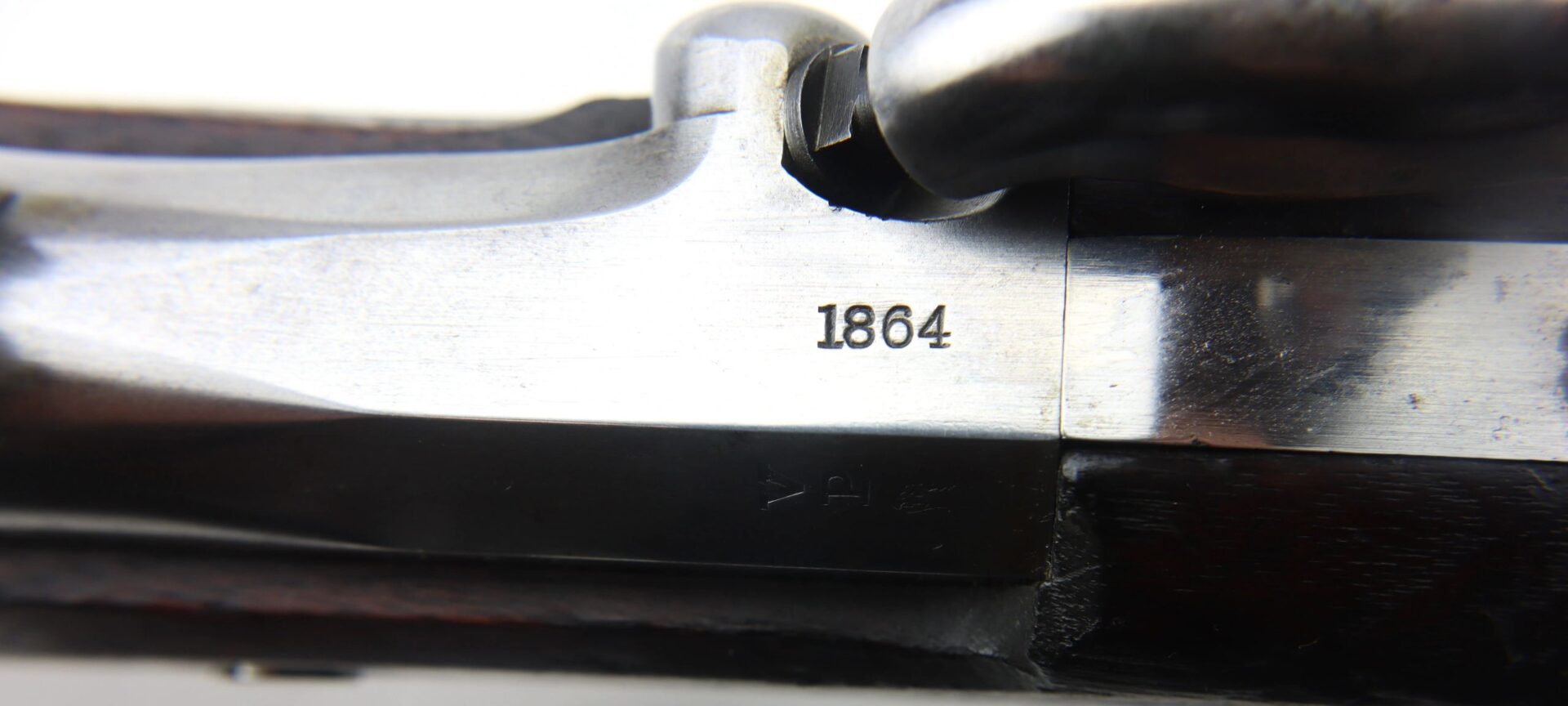 Close-up of a U.S. Model 1861 Special Colt Contract Rifle Musket, dated 1864, showing the engraved number "1864" on its metal surface.