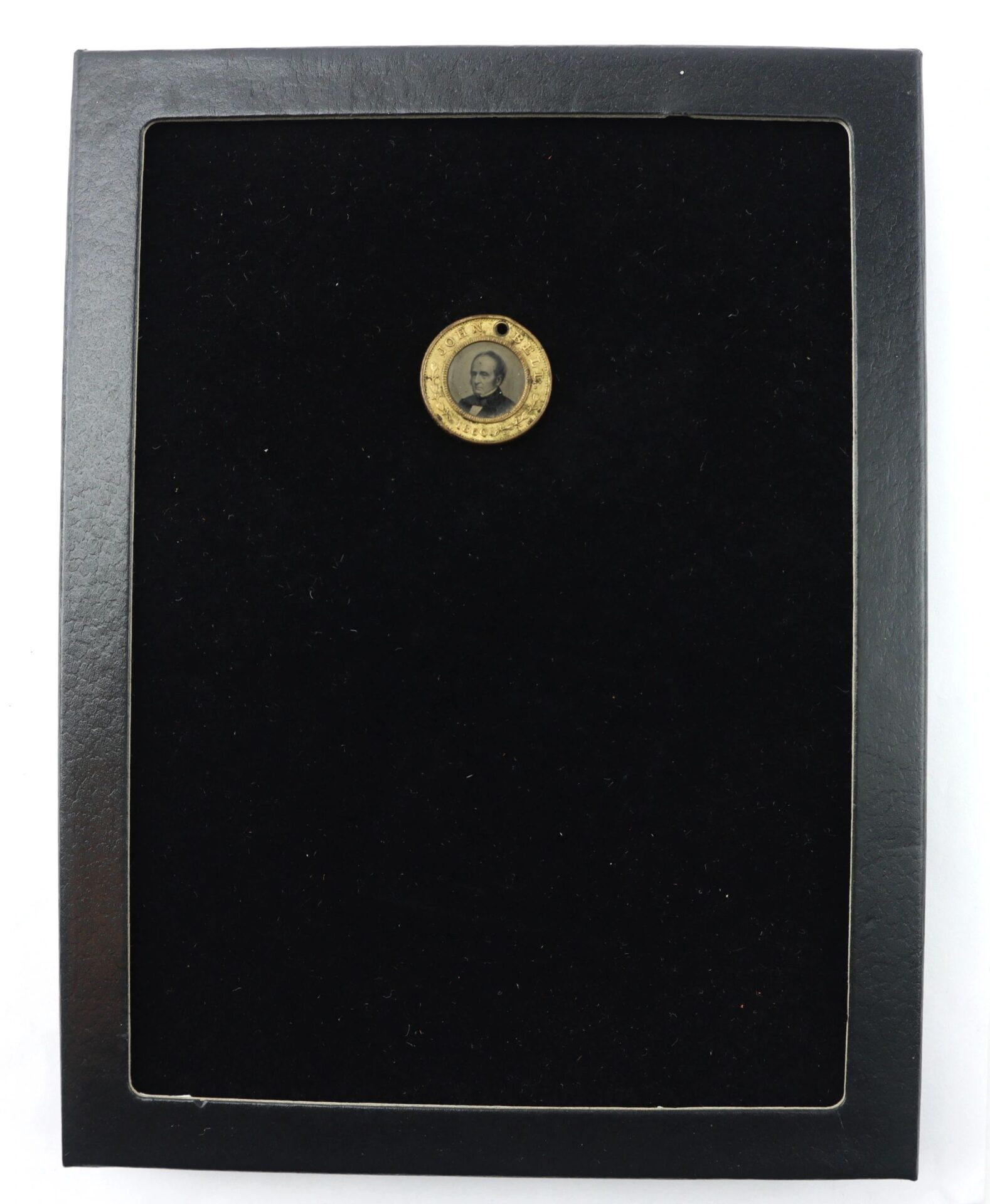 The Bell / Everett Campaign Token is a small round pendant showcasing a black-and-white portrait of a man, centered on a black rectangular display with a thin border.