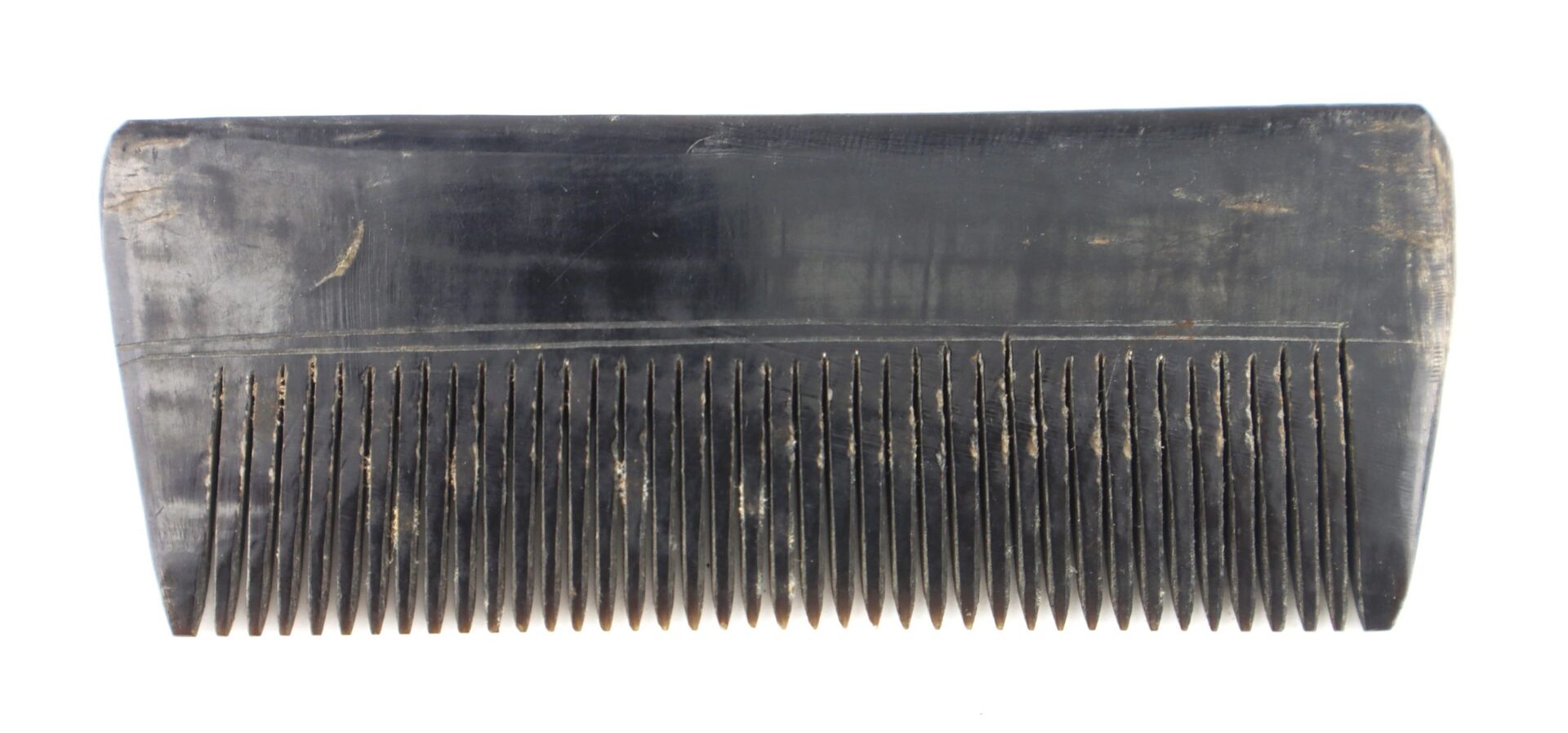 A close-up of the Civil War Comb, constructed of horn, showing wide teeth and visible scratches; SOLD.