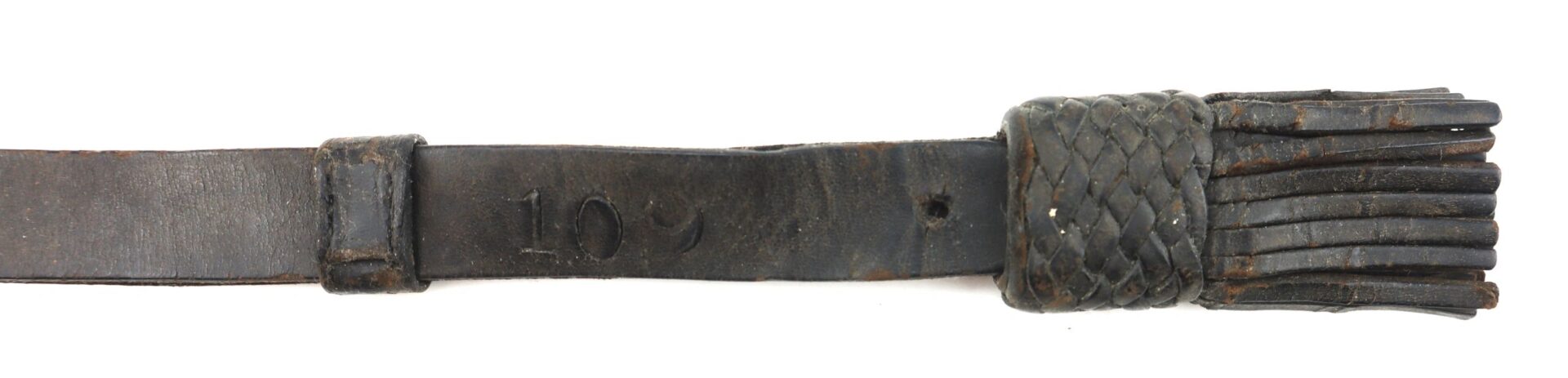 A close-up of the Civil War Saber Knot, showing its worn leather, braided handle, and the number "10" stamped on the strap.