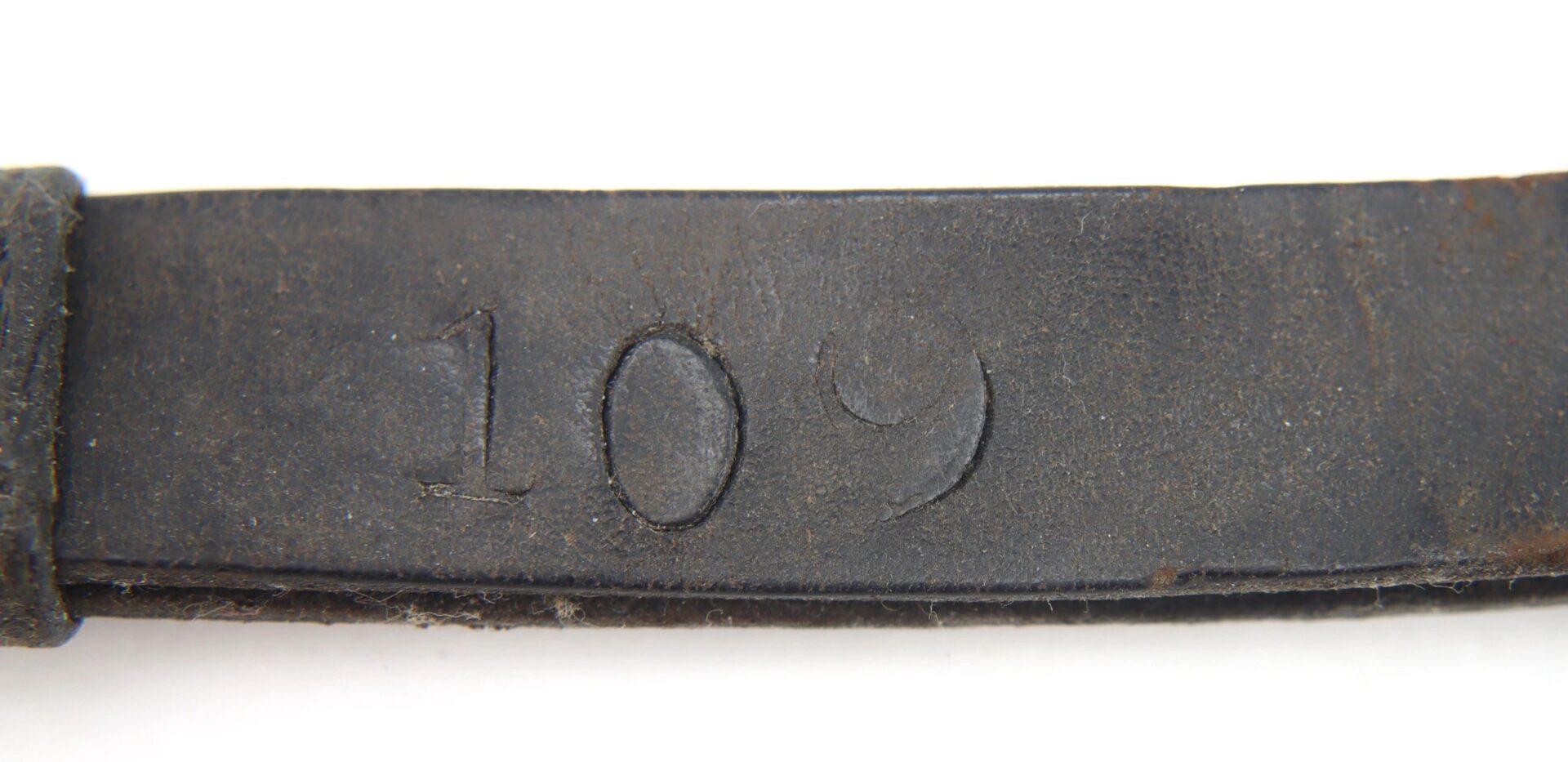 Close-up of a dark leather strap from the Civil War Saber Knot, embossed with the number "109.