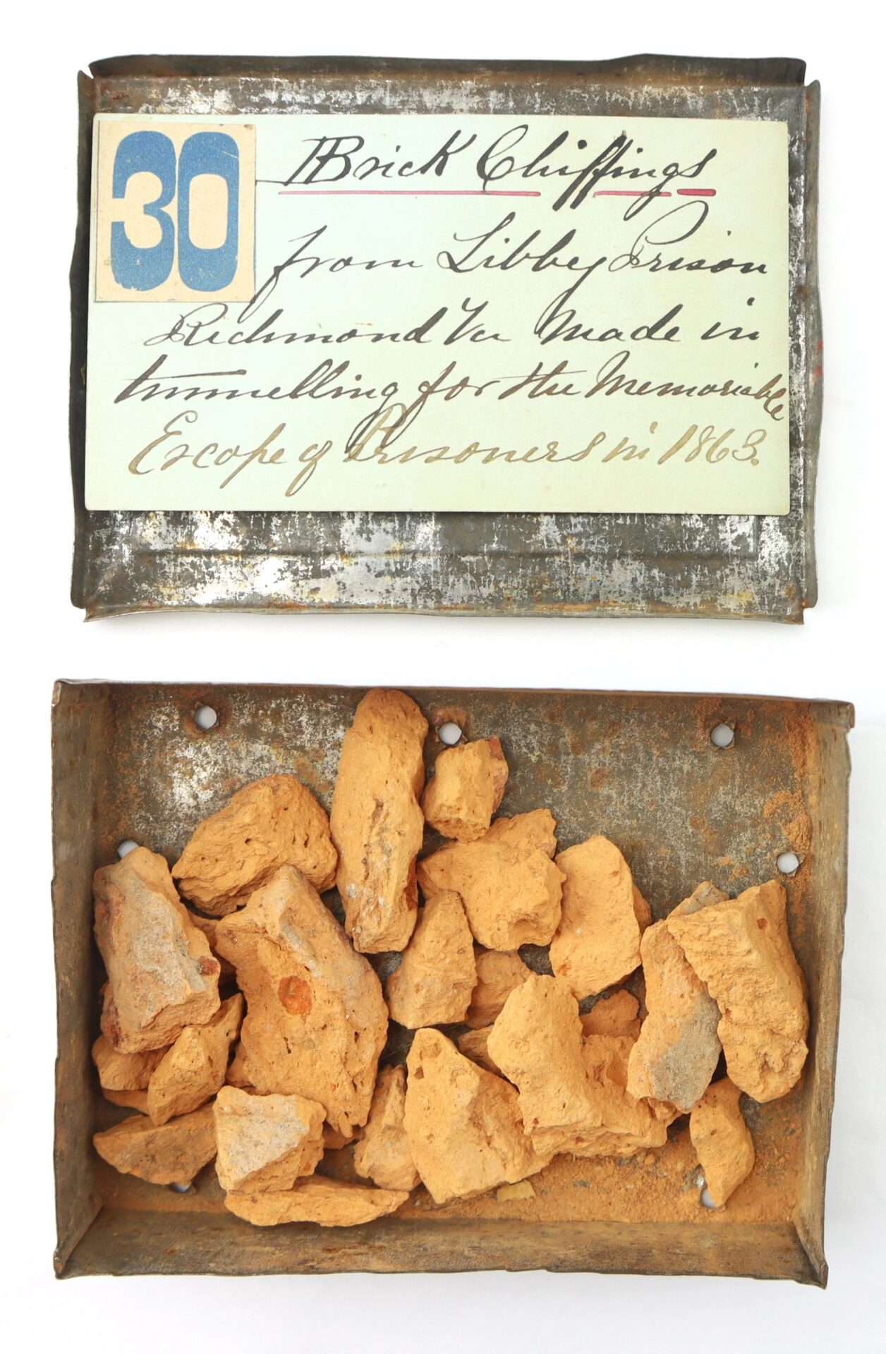 An Important Libby Prison Relic: A metal box with orange brick fragments labeled as from Libby Prison, Richmond, VA, collected in 1863. SOLD.
