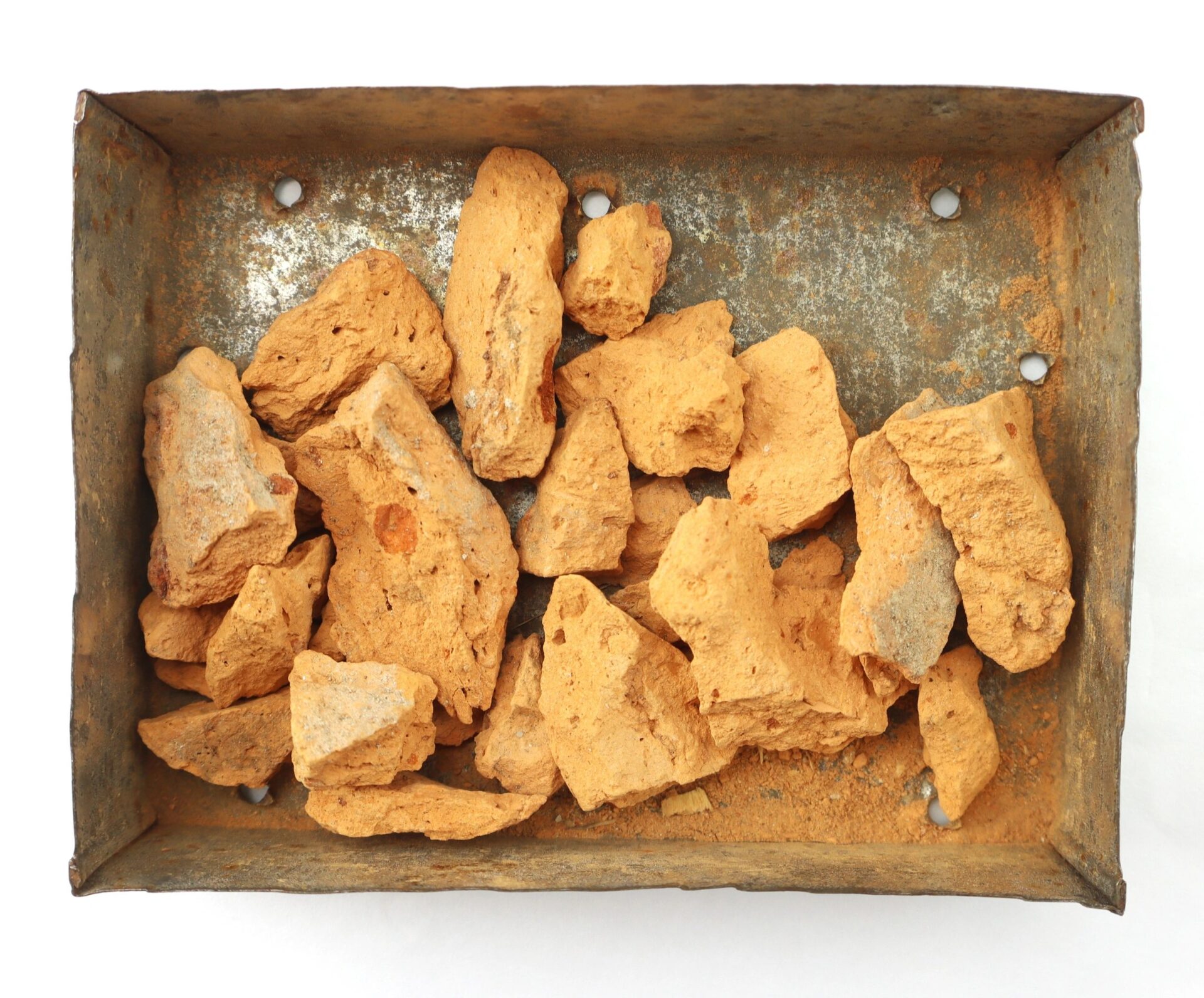 A rectangular metal tray with irregular orange-brown ochre rocks, tagged as "Important Libby Prison Relic / SOLD," viewed from above on a white background.