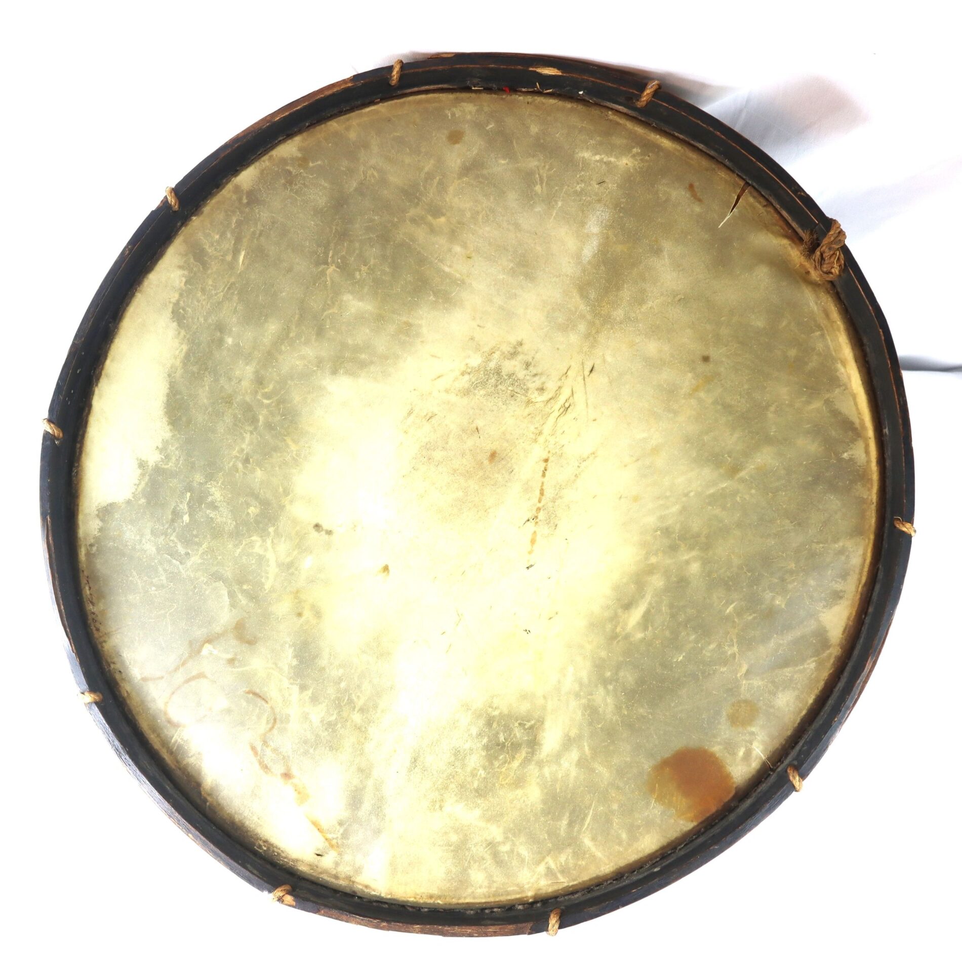 A close-up of the “Galvanized Yankees” Regimental Bass Drum of the 1st U.S. Volunteers shows its round shape, natural skin surface, and dark wooden frame with signs of discoloration and wear.
