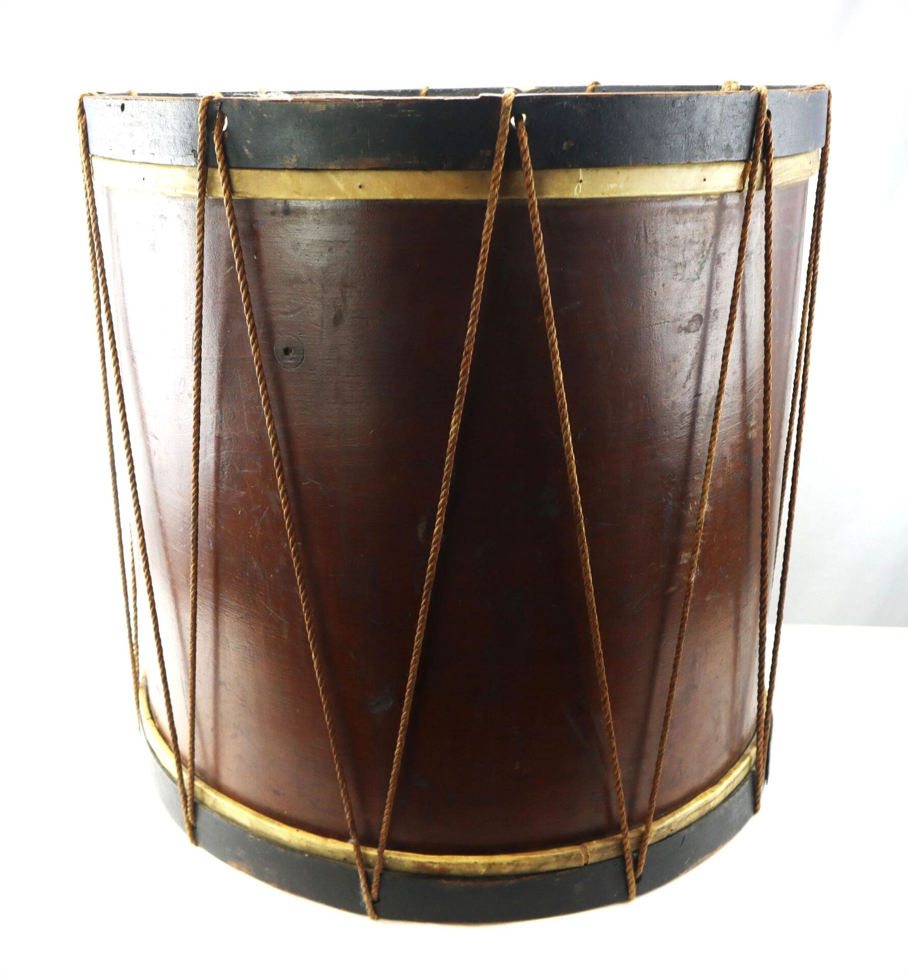 The “Galvanized Yankees” Regimental Bass Drum of the 1st U.S. Volunteers is a large, cylindrical wooden drum featuring a dark brown body, black and gold rims, and rope tensioning.